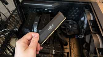 A photo of someone holding a RAM stick in front of a PC with the side panel off
