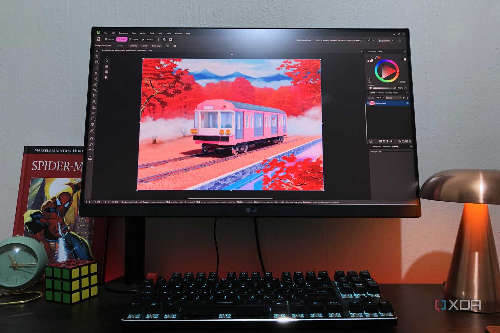 Affinity on desktop PC with train graphics, lamp and book in view