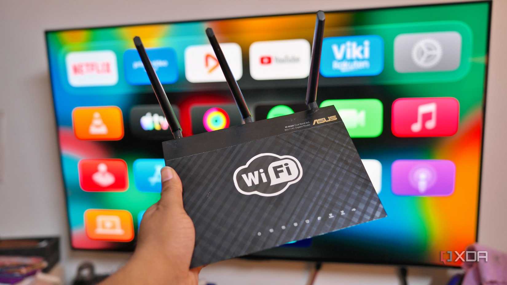 A WiFI-7 router in front of a TV with many online applications used at home