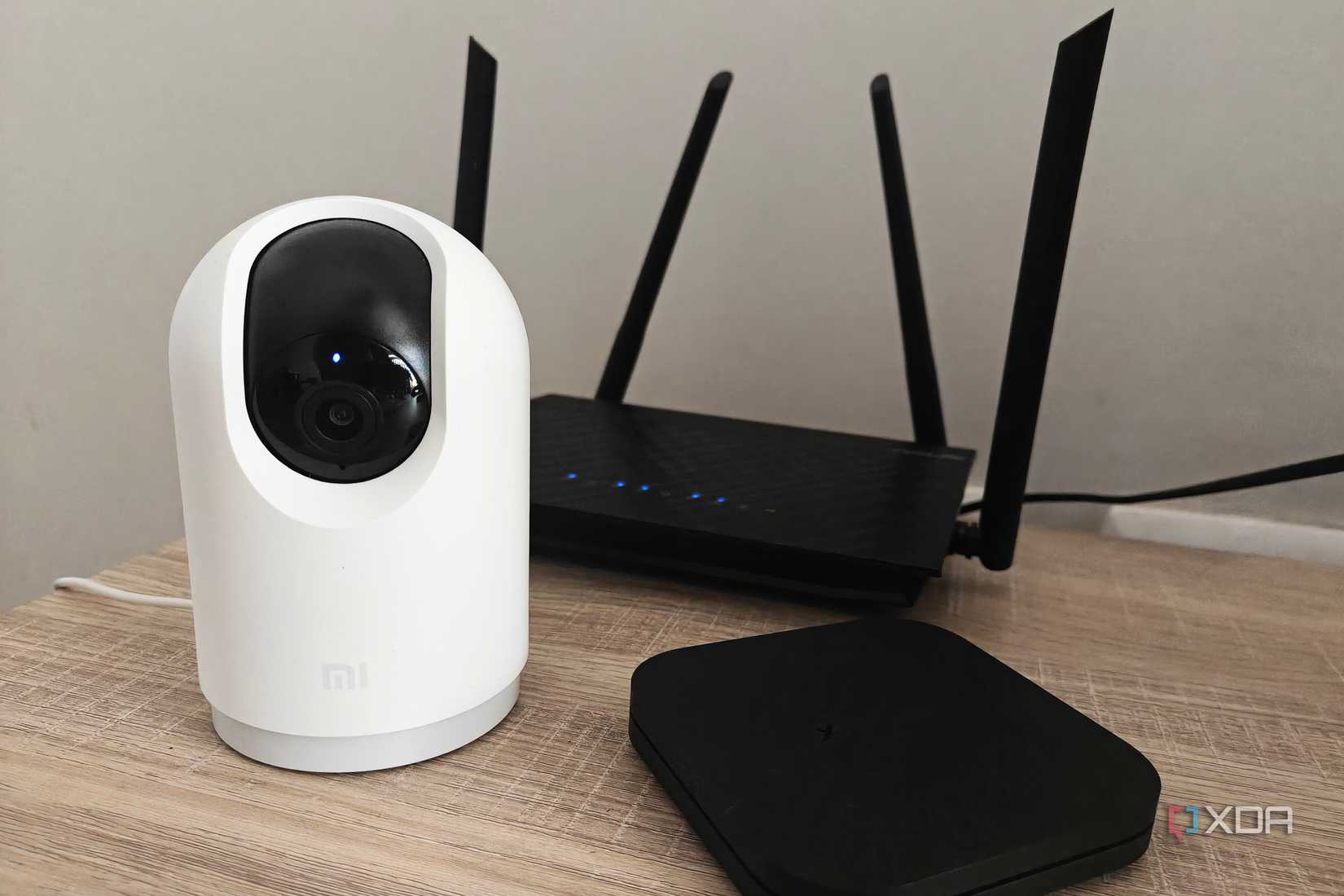 dispositivos domésticos inteligentes sobre una mesa que incluyen una cámara y una caja de televisión