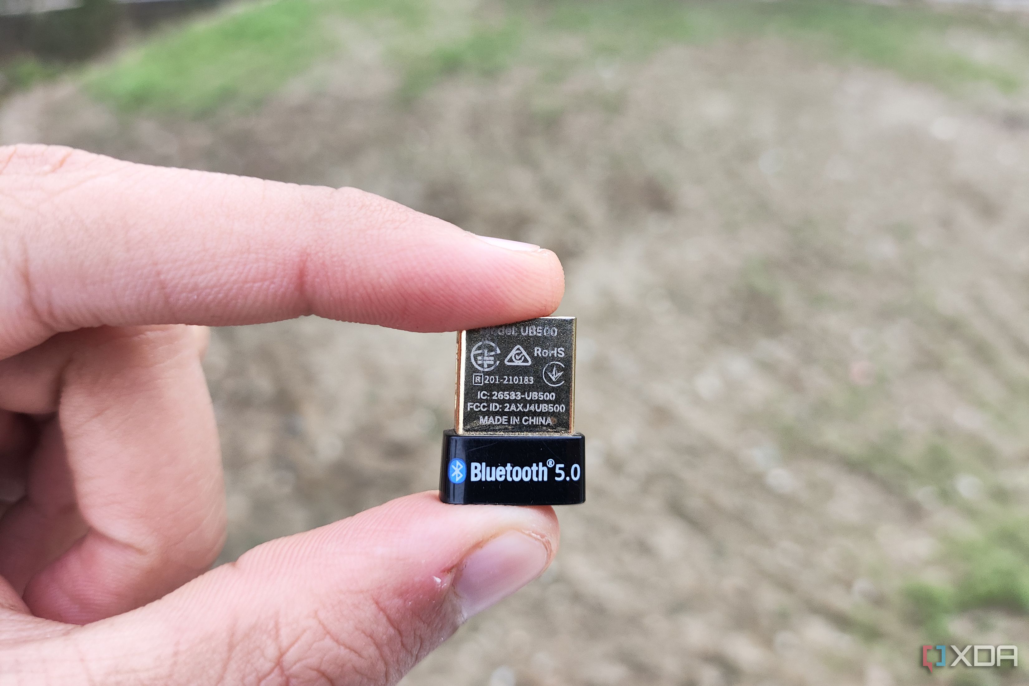 A person holding a Bluetooth dongle