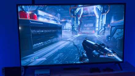 A TV showing DOOM 2016 running on Bazzite with a performance overlay in the top left corner