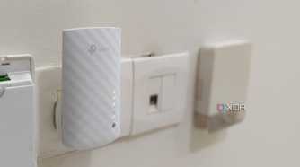 A white Wi-Fi extender plugged into a wall outlet