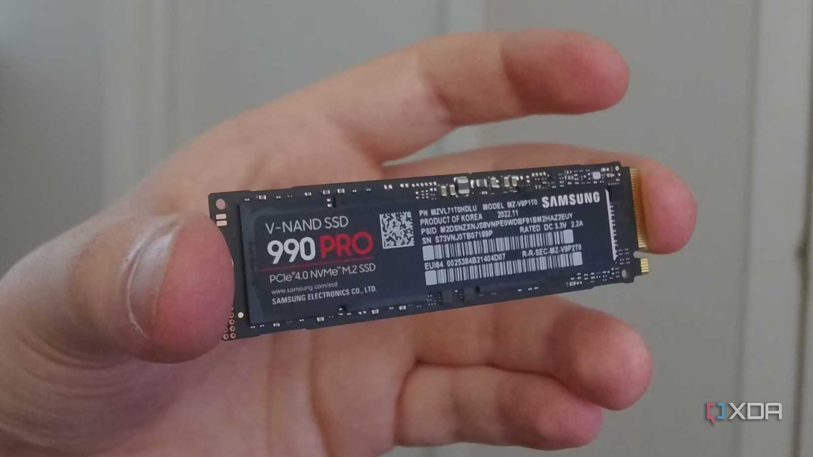 Hand holding a Samsung 990 Pro SSD