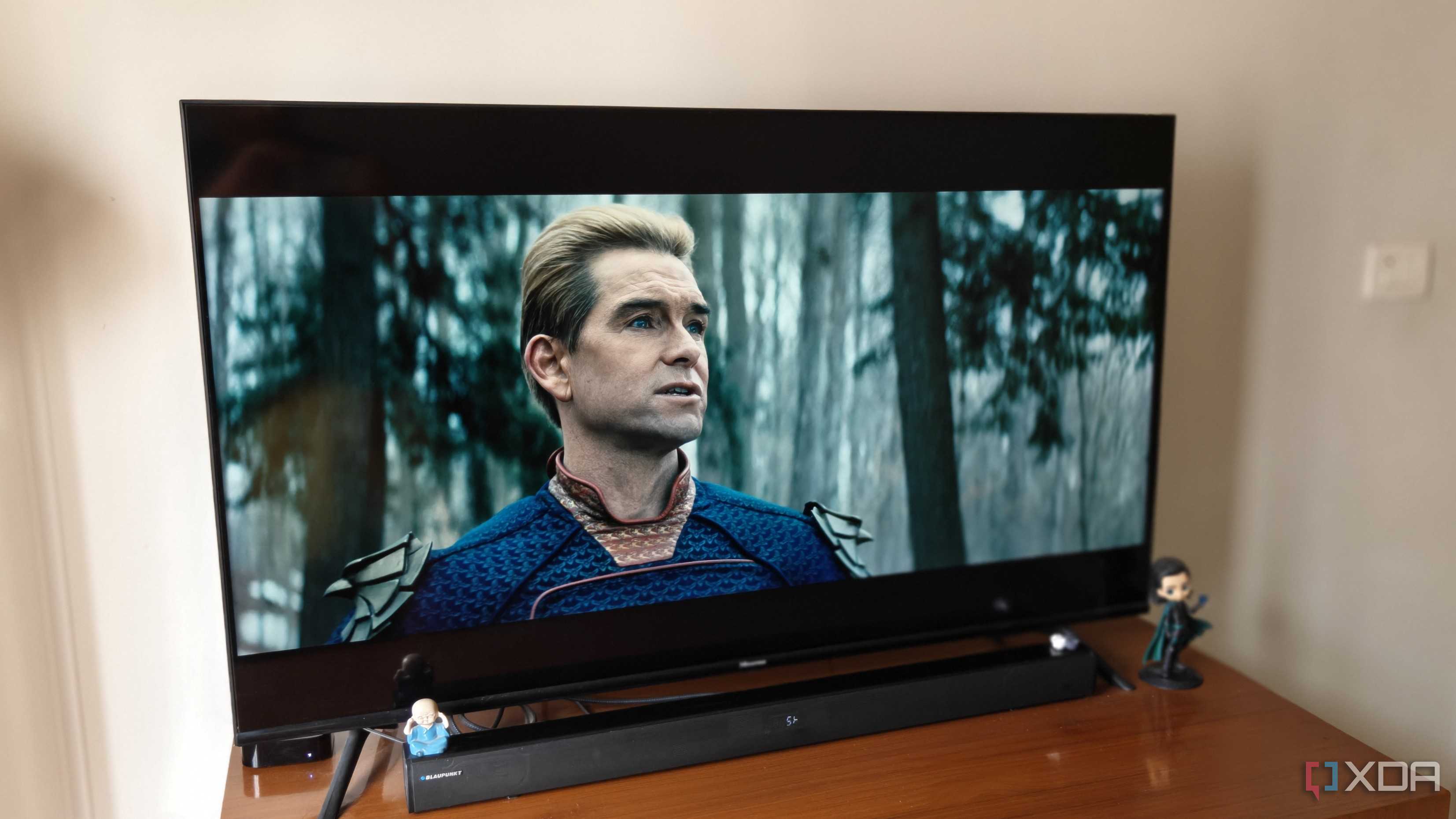 A smart TV on a brown table showing a scene from The Boys