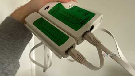 A photo of someone holding an ethernet cable continuity tester