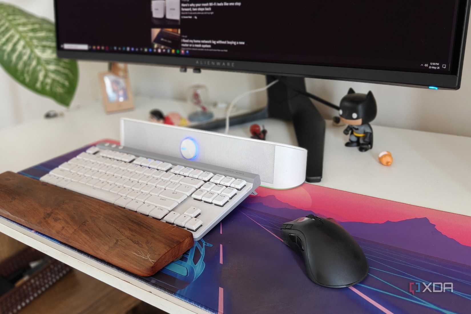 A mouse and keyboard on a deskmat next to a monitor