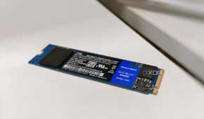 A blue SSD without a heatsink placed on a white desk