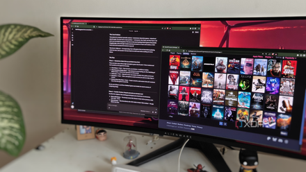 An ultra-wide monitor showing the Claude window next to a window with several game posters