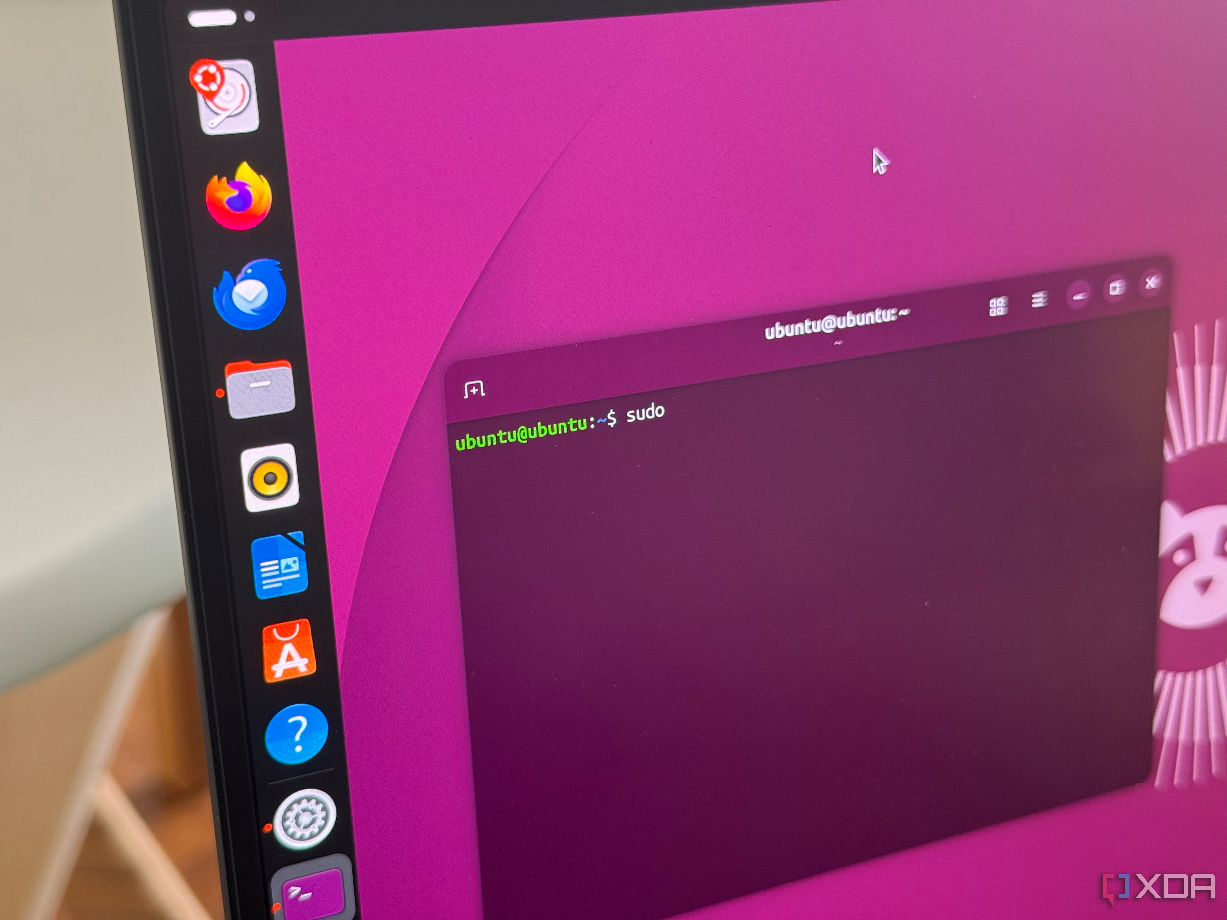 A photo of a laptop with an Ubuntu Linux terminal open, showing the sudo command