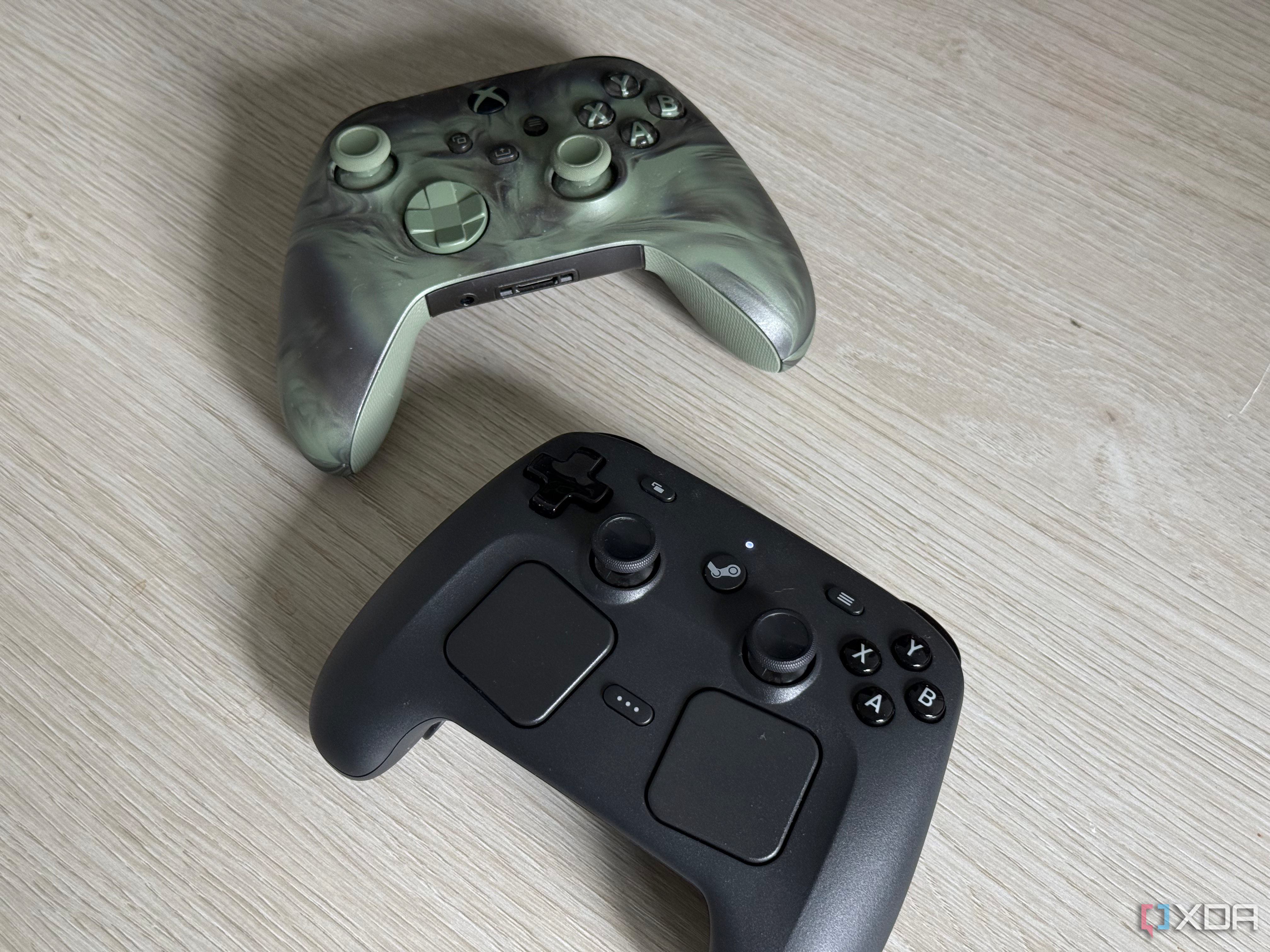 A Steam Controller and Xbox Controller side by side on a table