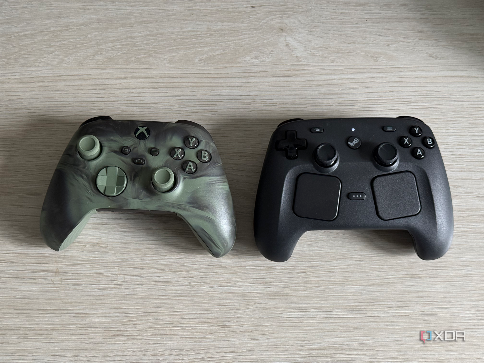A Steam controller and an Xbox controller side by side on a table