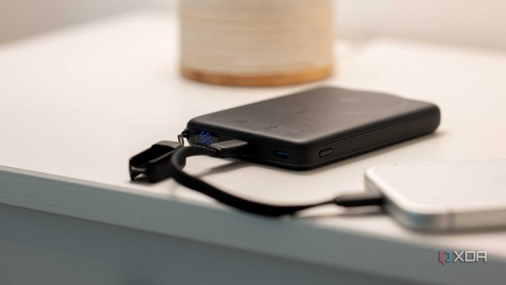 INIU SnapGo Air Power Bank with charging cable on a white countertop
