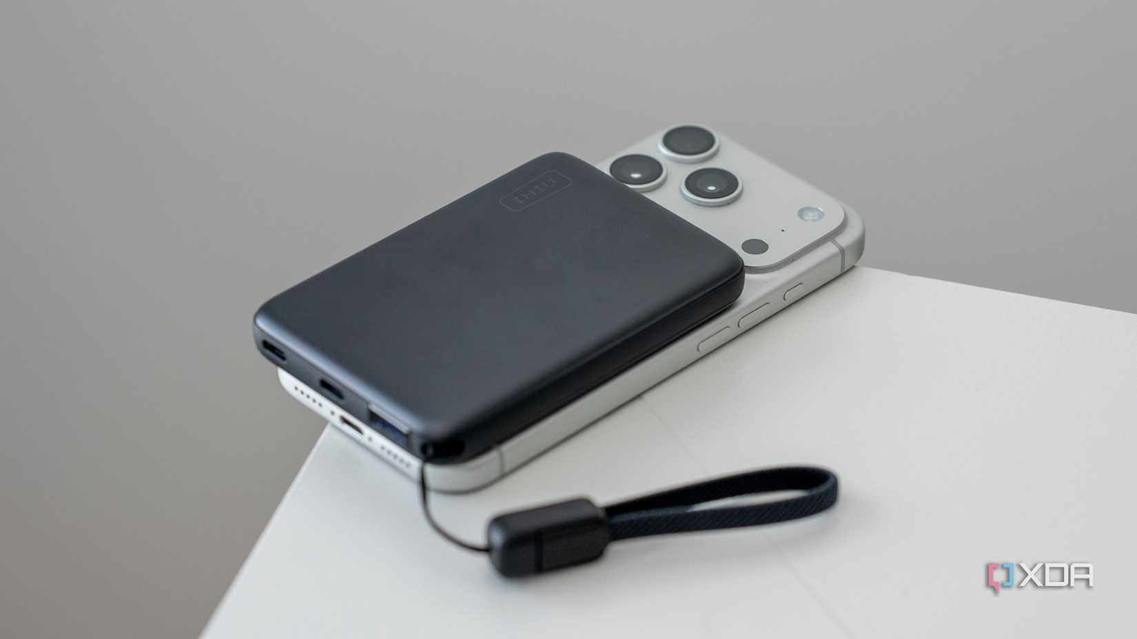 The INIU SnapGo Air Power Bank MagSafe charging a phone on a white table