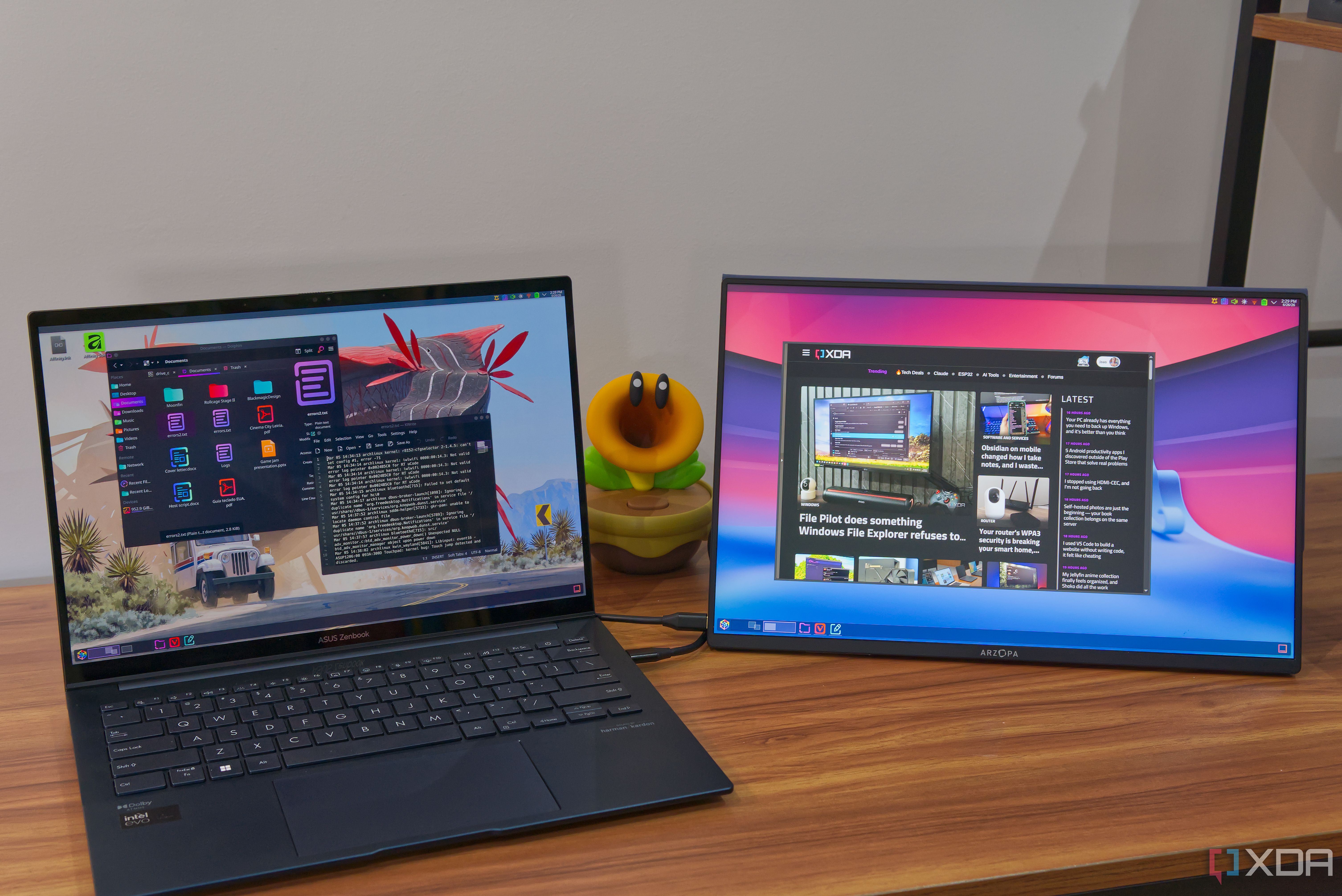 A laptop running KDE Plasma connected to a portable monitor. The laptop is displaying apps from virtual desktop 1, while the portable monitor is displaying apps from desktop 2
