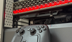 A photo of a steam controller sitting in front of a PC build