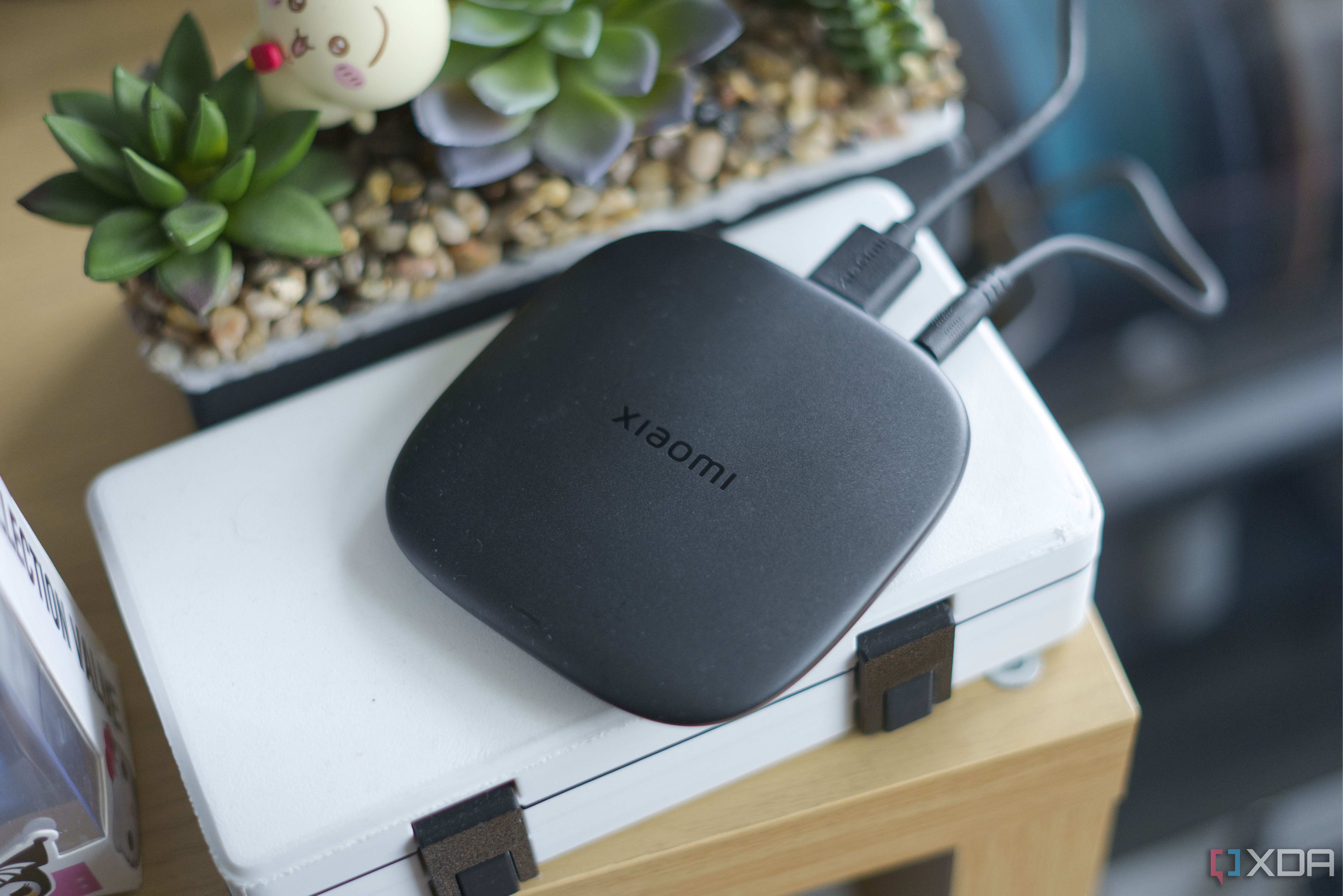 Xiaomi TV Box S 3rd Gen body, on top of a case with shrubbery behind it