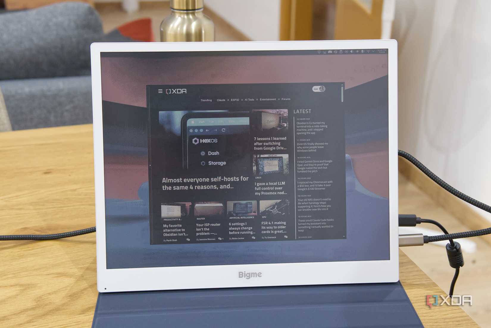 A Bigme B13 portable monitor displaying the XDA homepage over a a desktop background in KDE Plasma