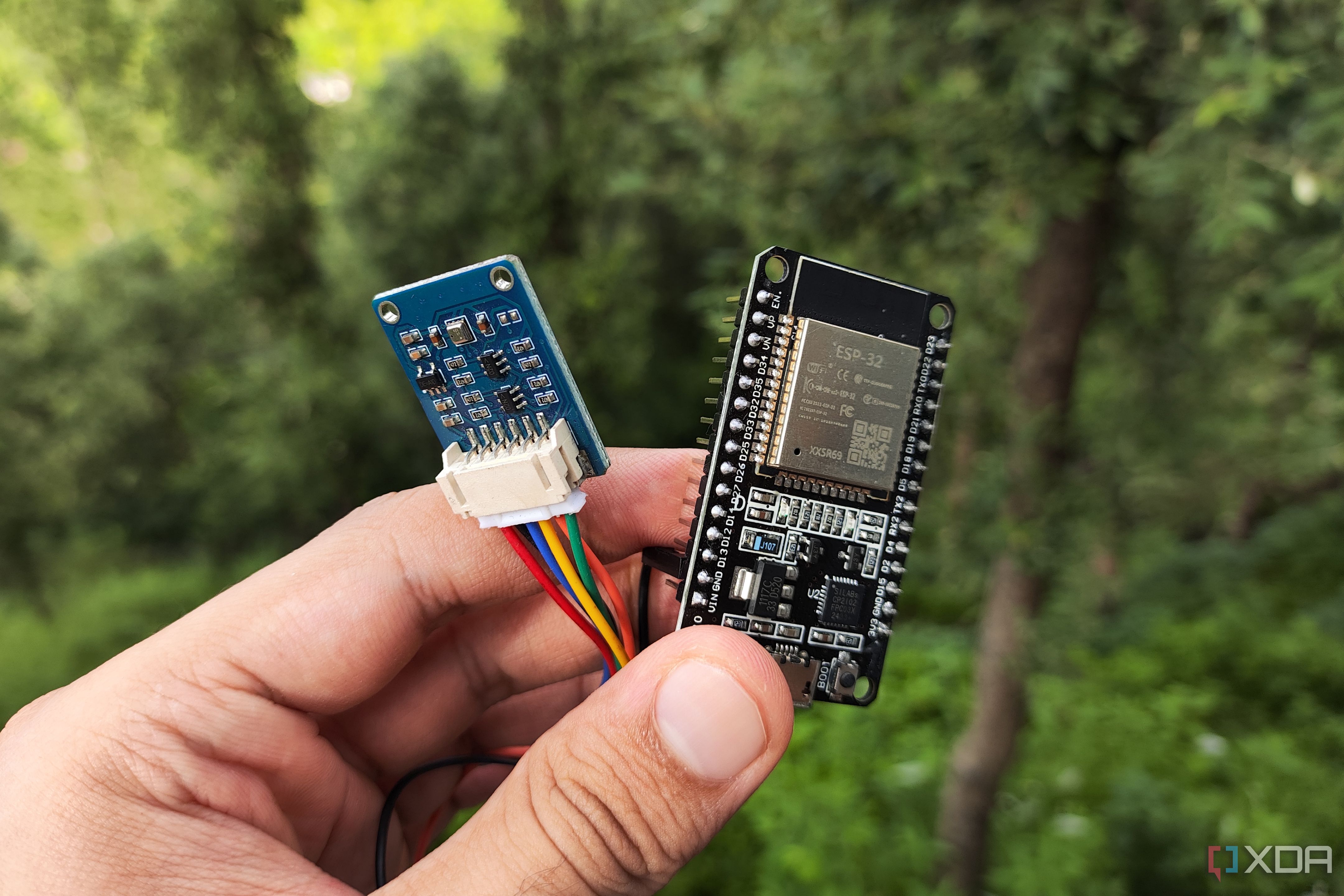 A person holding an ESP32 connected to a BME280