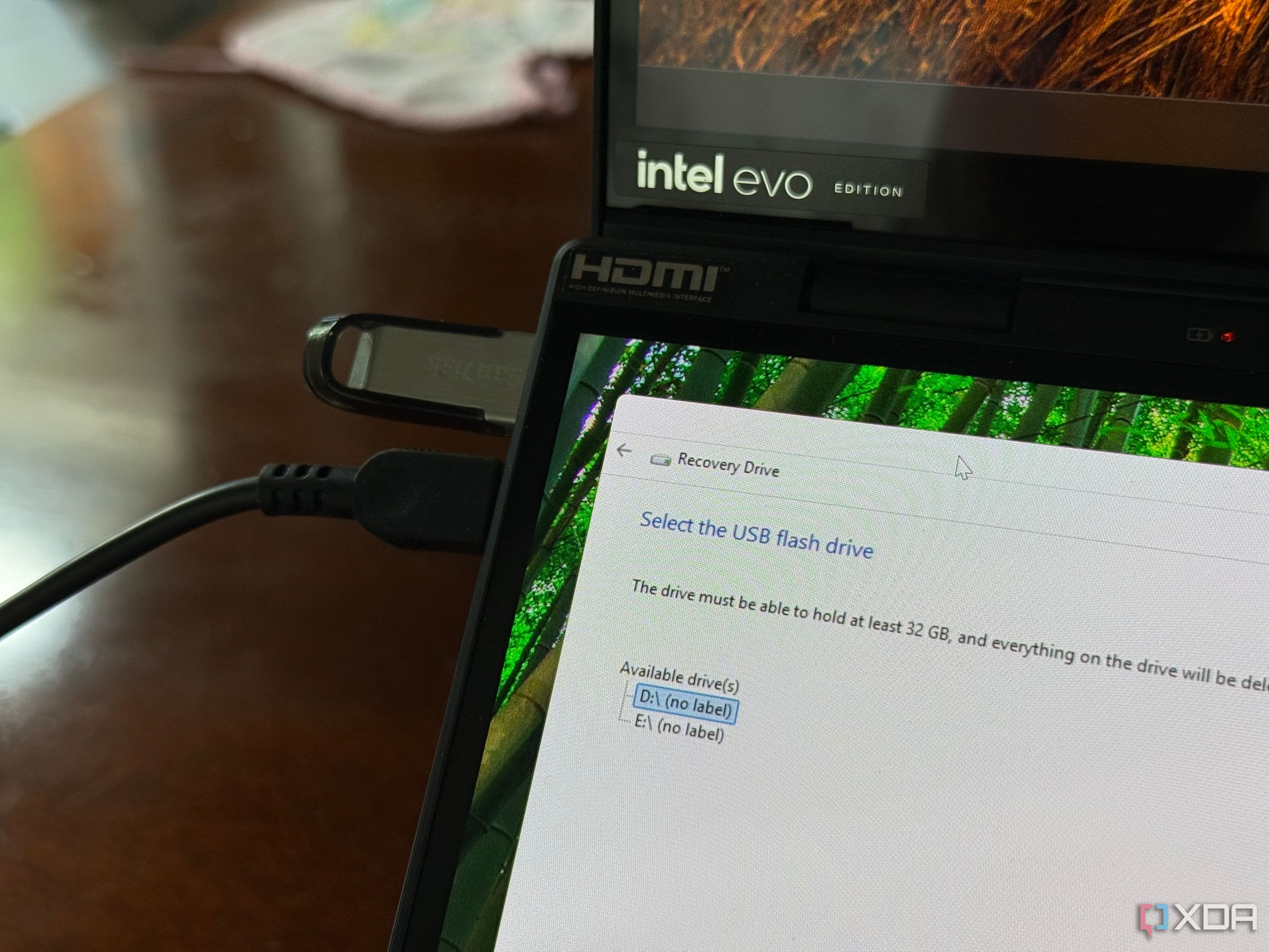 A USB drive plugged into a laptop with the Windows Recovery Drive creation wizard open
