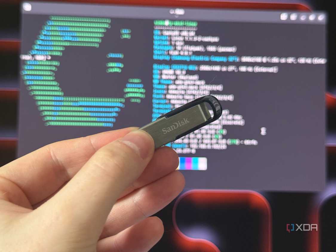 a sandisk USB drive held in front of a monitor showing cachyos