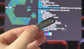 a sandisk USB drive held in front of a monitor showing cachyos