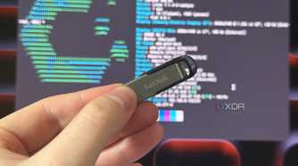 a sandisk USB drive held in front of a monitor showing cachyos