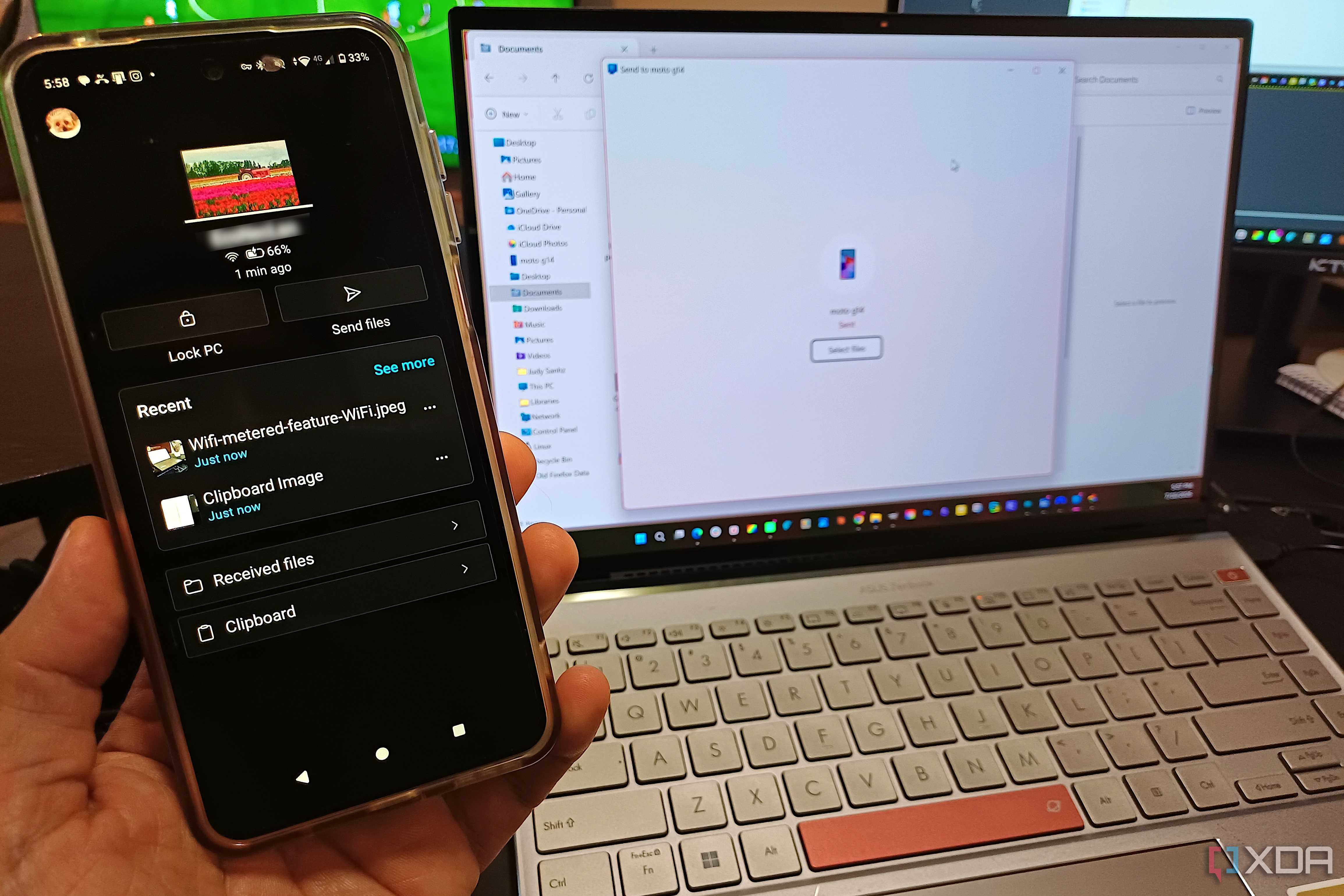 A hand holding an Android phone with Phone Link app showing