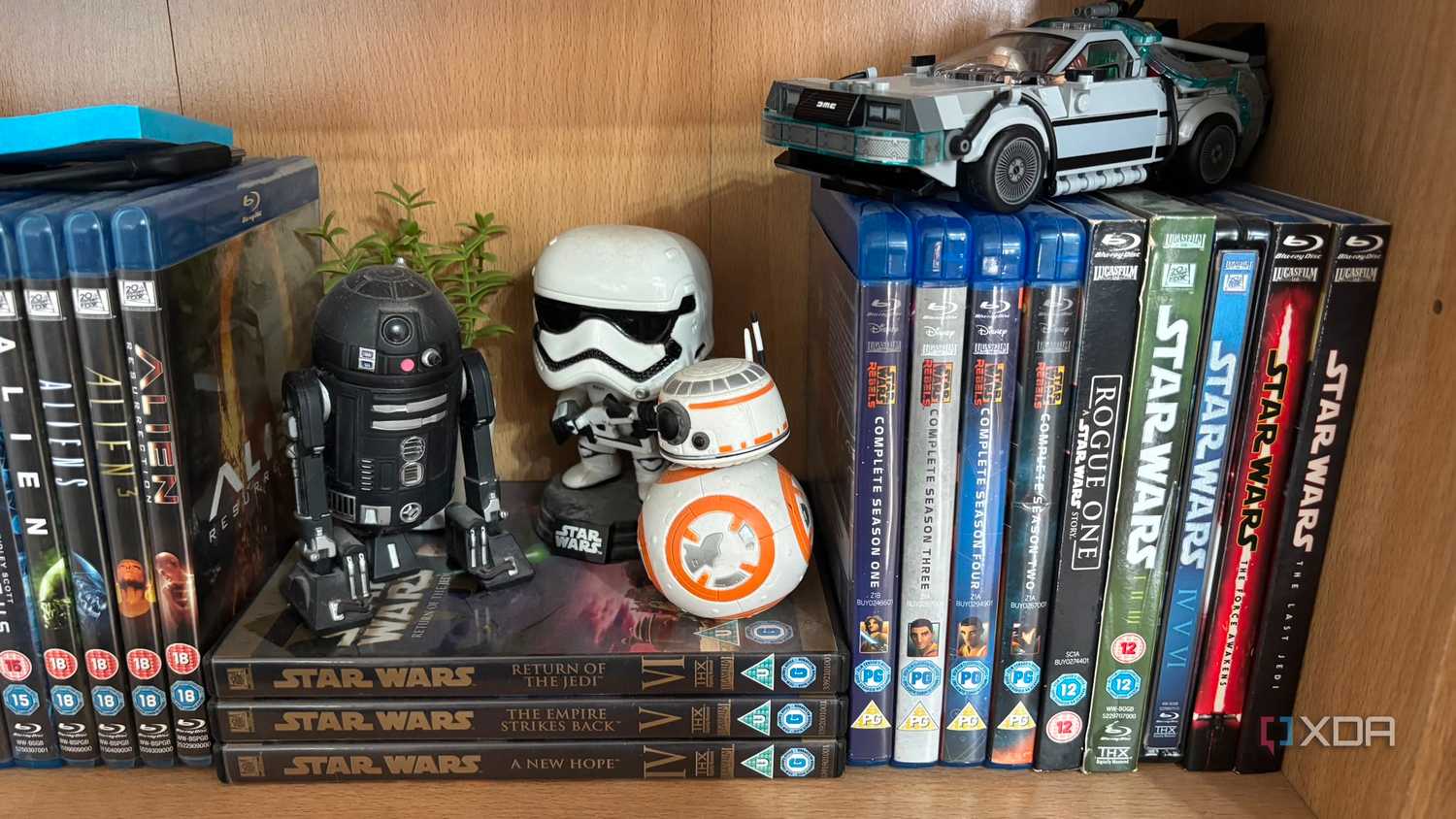 Коллекция Blu-ray дисков на полке Полка с коллекцией физических носителей Blu-ray и фигурками