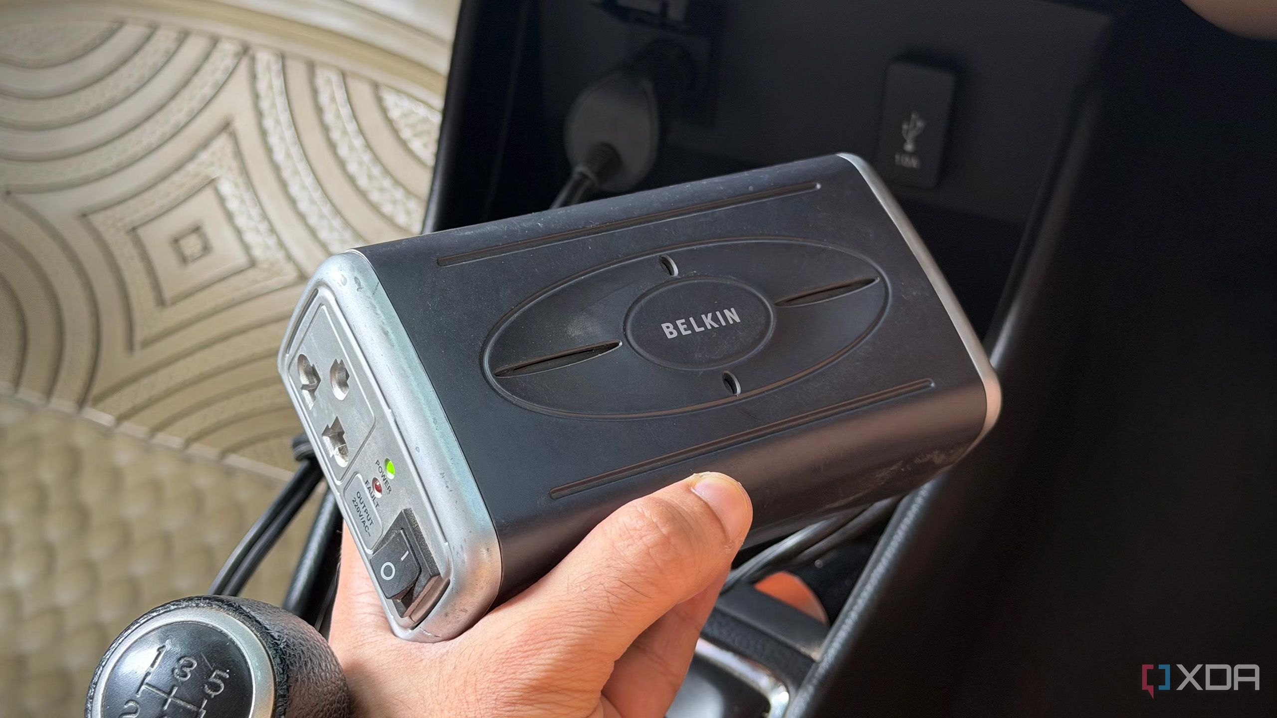A 12V car inverter being held 