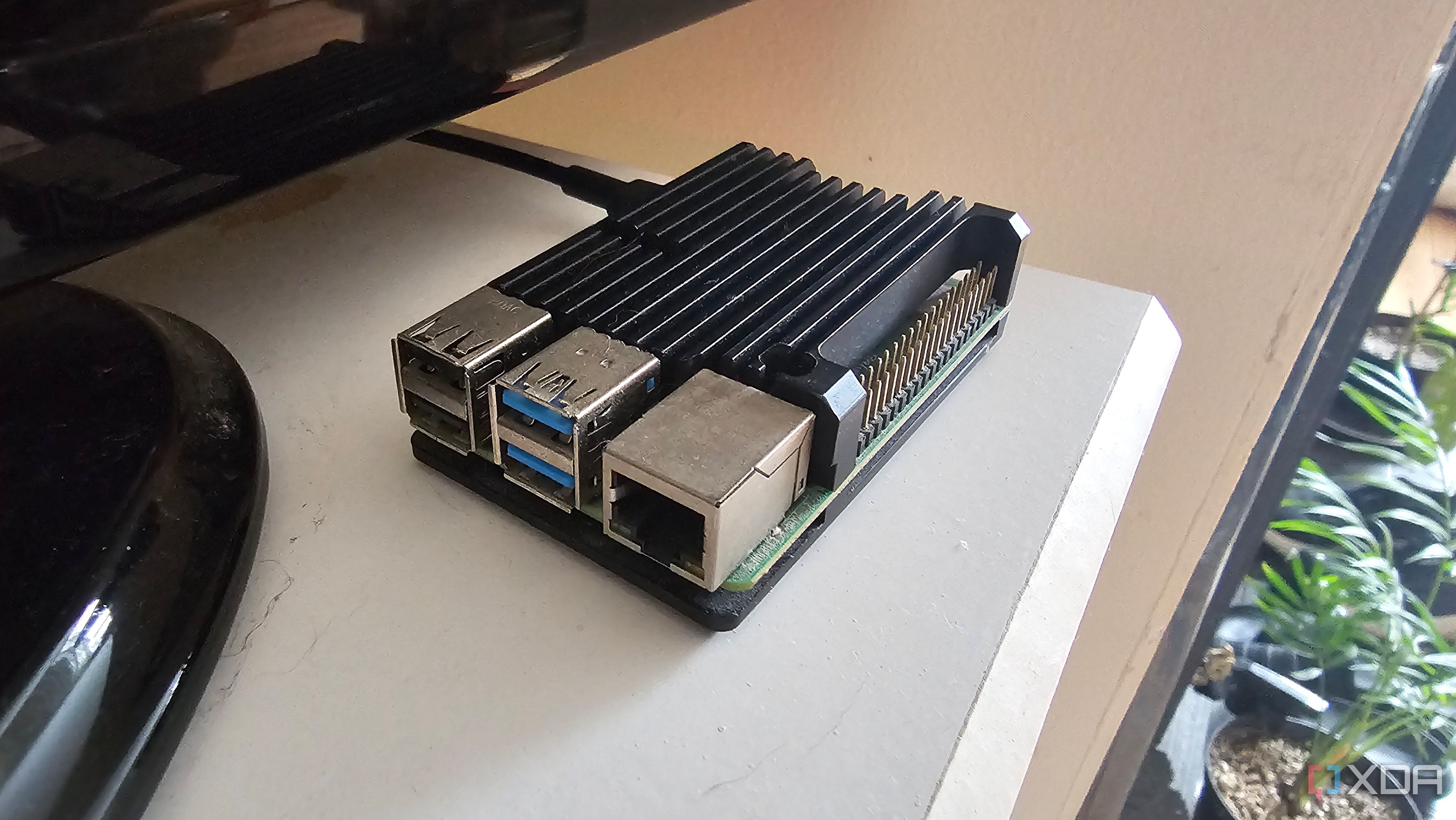 A Raspberry Pi with a heatsink sitting on the corner of a set of drawers