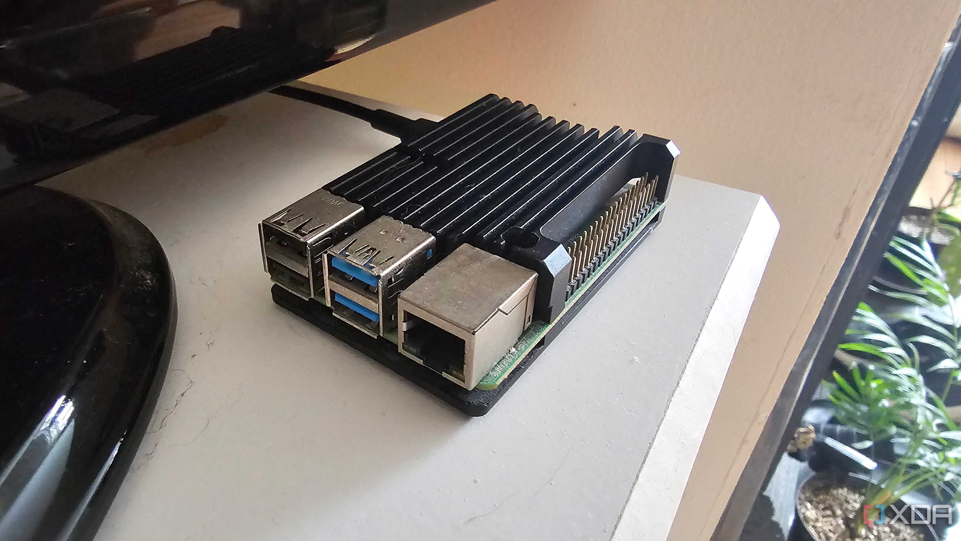 A Raspberry Pi with a heatsink sitting on the corner of a set of drawers