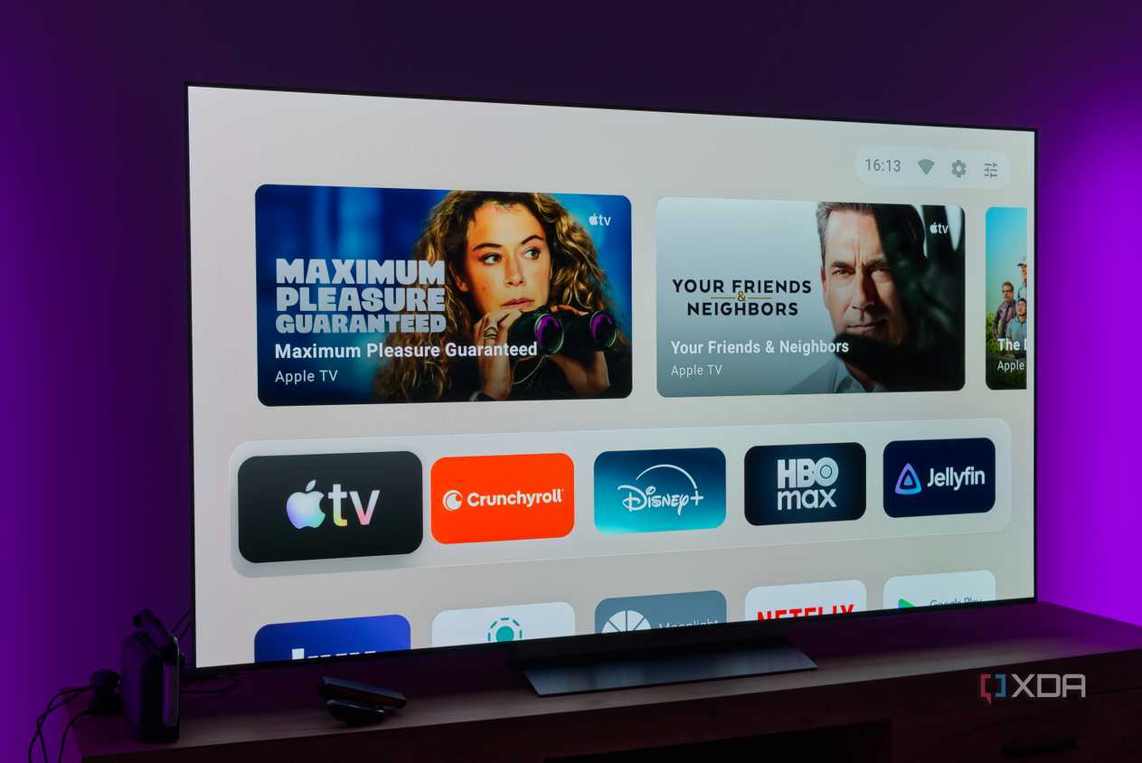 A TV showing the default home page on the AT4K Launcher, showing featured cards and favorite apps on a light background