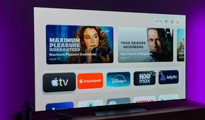 A TV showing the default home page on the AT4K Launcher, showing featured cards and favorite apps on a light background