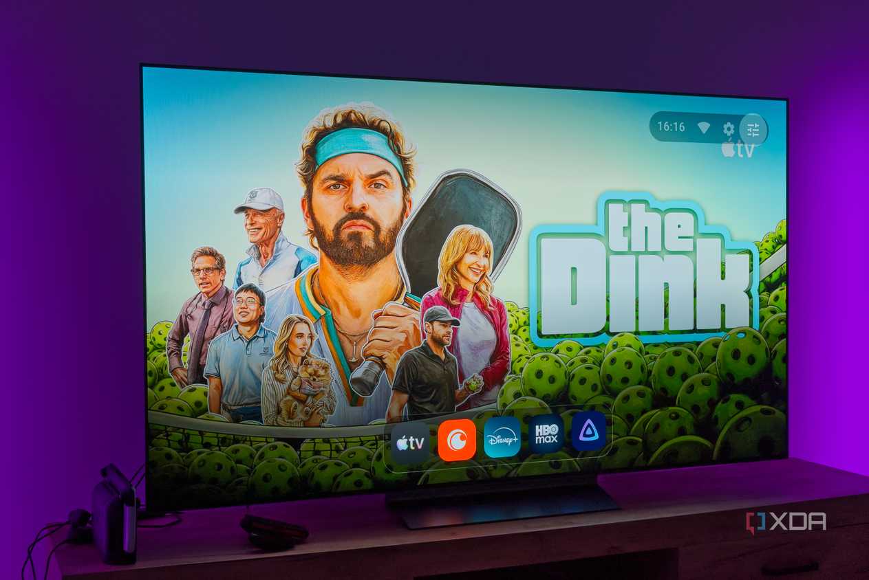 A TV displaying the homepage for AT4K Launcher on Android TV, with a full-screen wallpaper based on recommended content and a dock showing favorite apps in miniature size