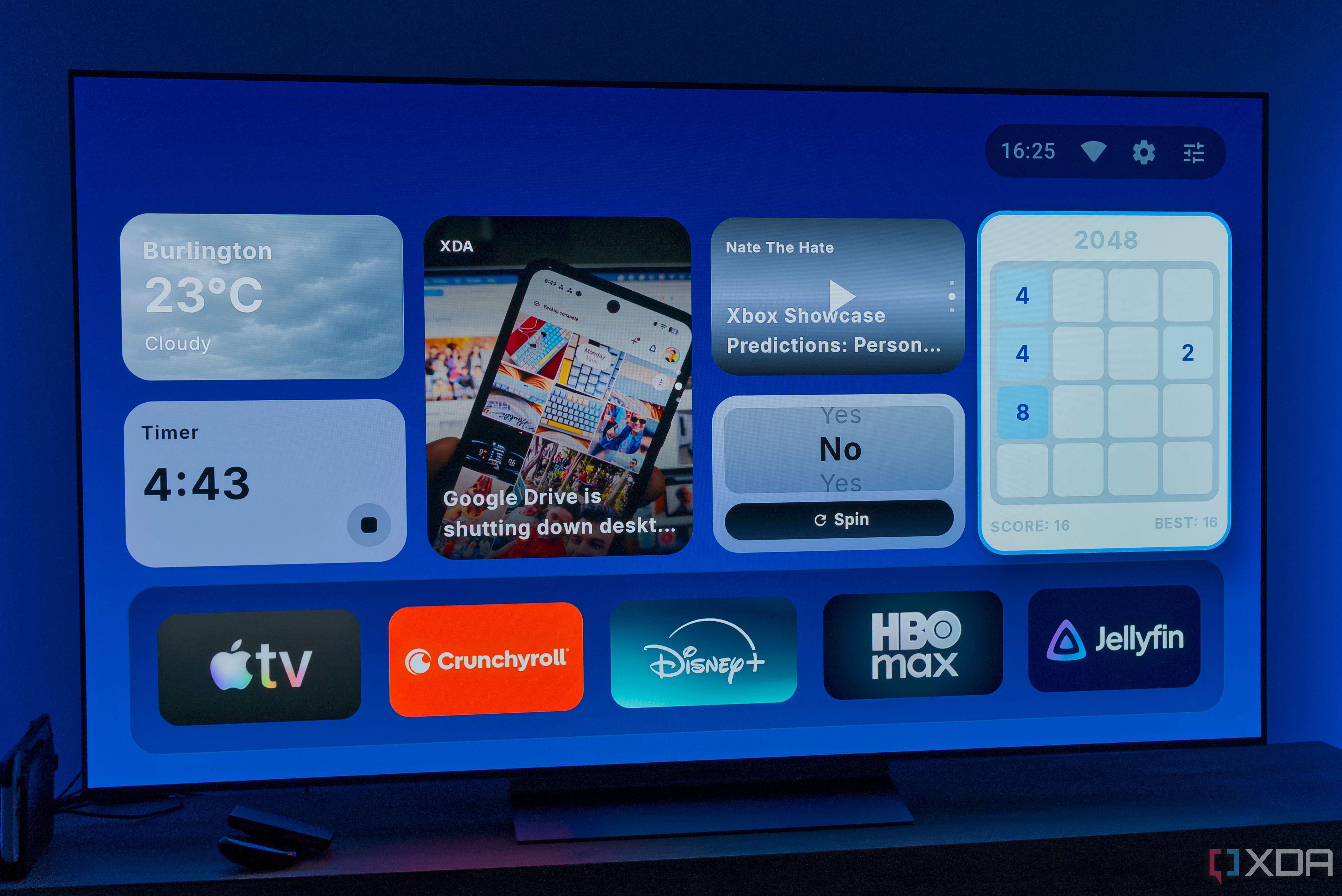 A TV displaying the homepage for AT4K Launcher for Android TV, with a small weather widget, a small timer widget, one full-size RSS feed widget for XDA, a small podcast widget, a small "Yes or no" spinner, and a 2048 game widget