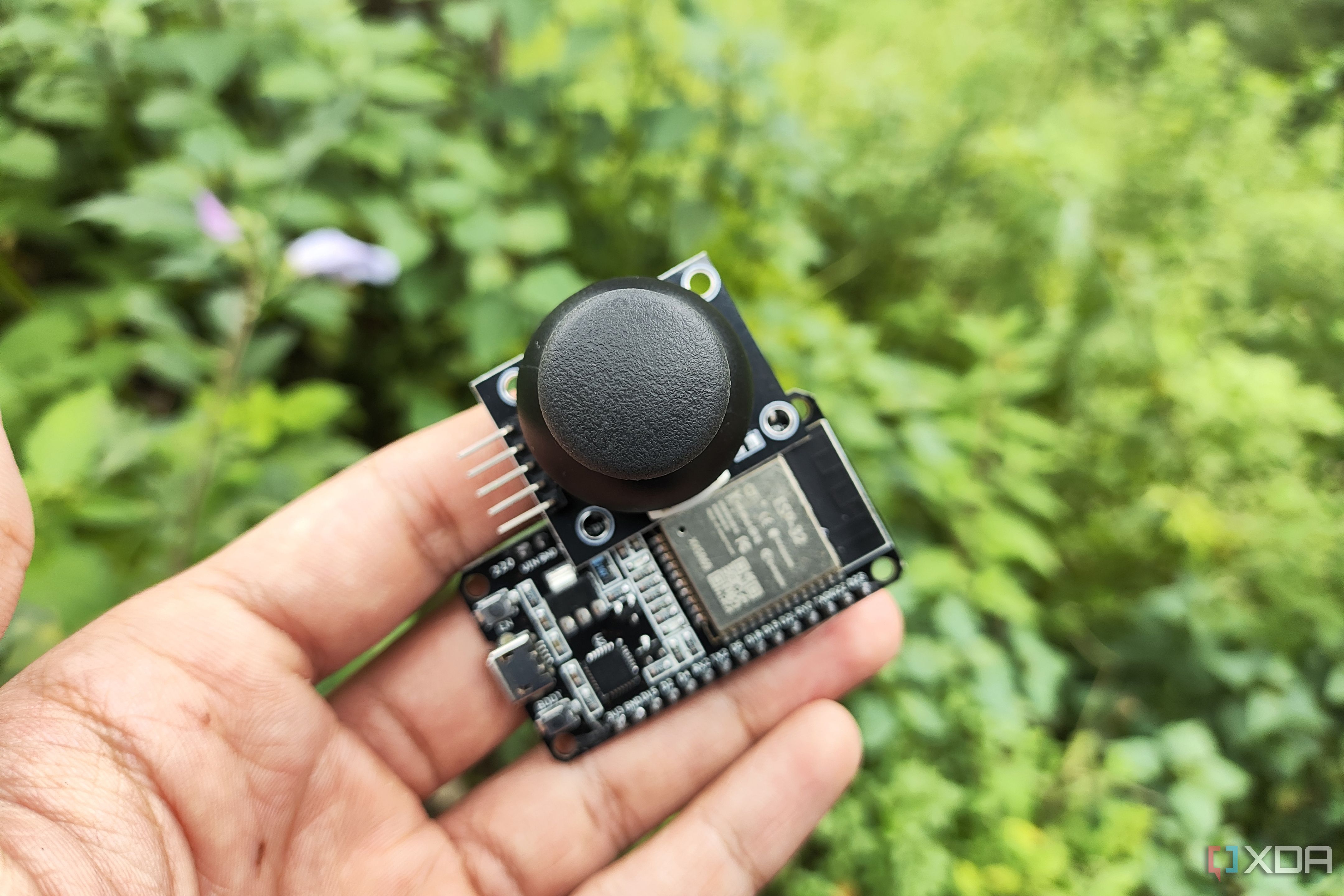 A person holding a joystick sensor with an ESP32