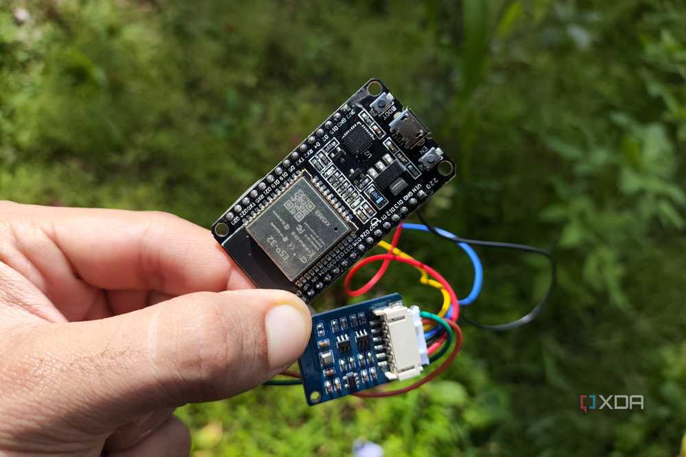 A person holding an ESP32 connected to a BME280