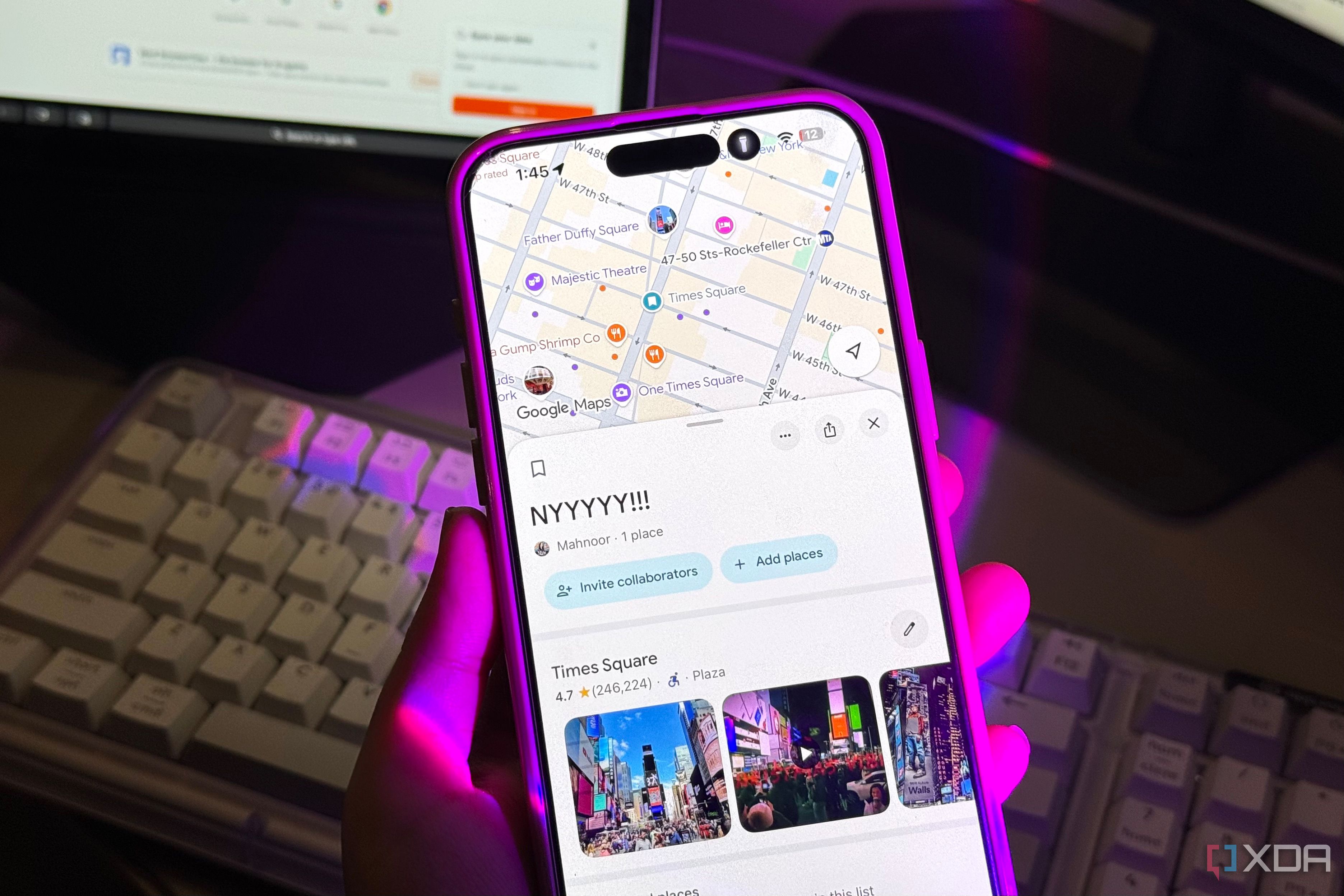 Google Maps Times Square list on an iPhone held above a cream mechanical keyboard