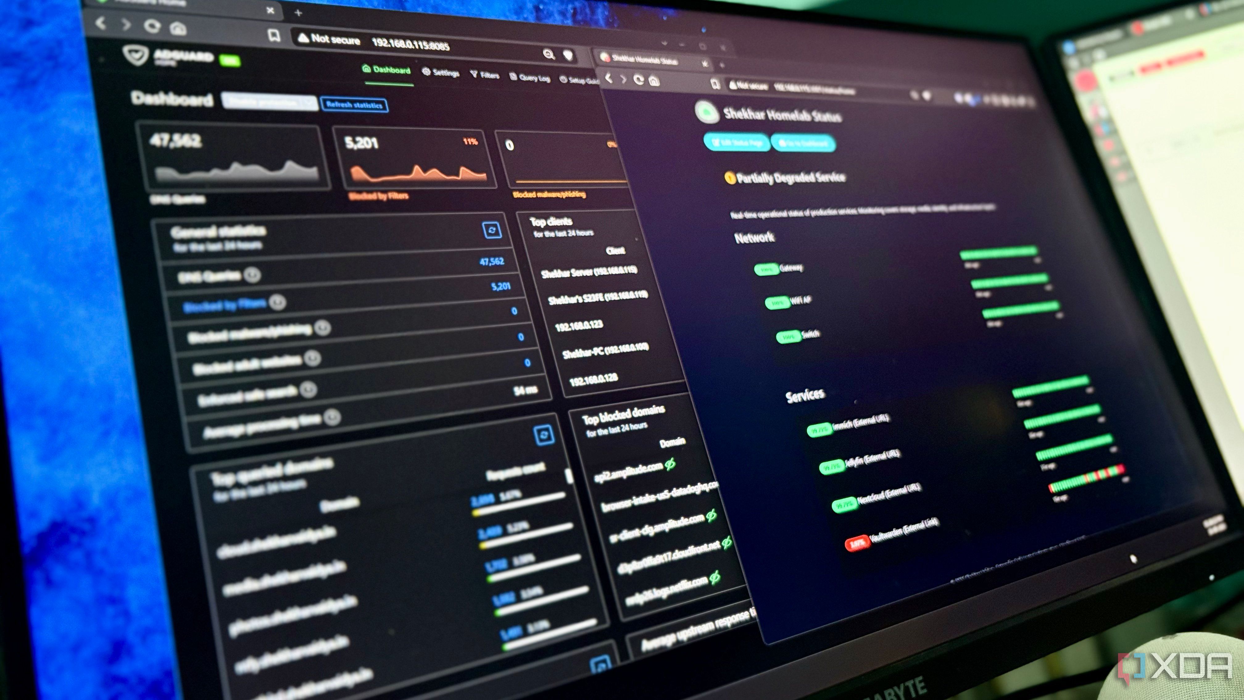 Two monitors displaying AdGuard Home and a homelab status dashboard showing network and service health