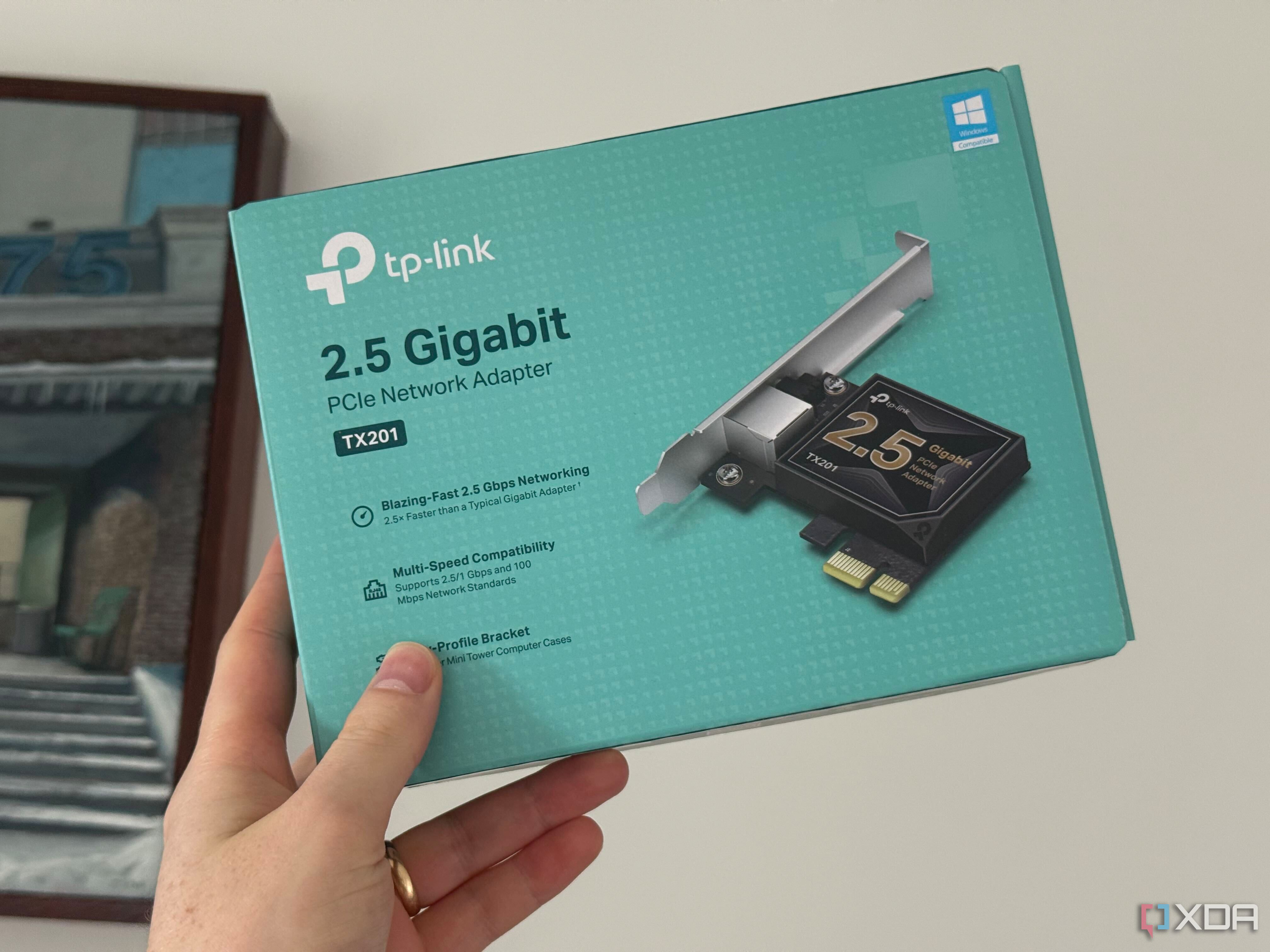 Someone holding a TP-Link NIC card box
