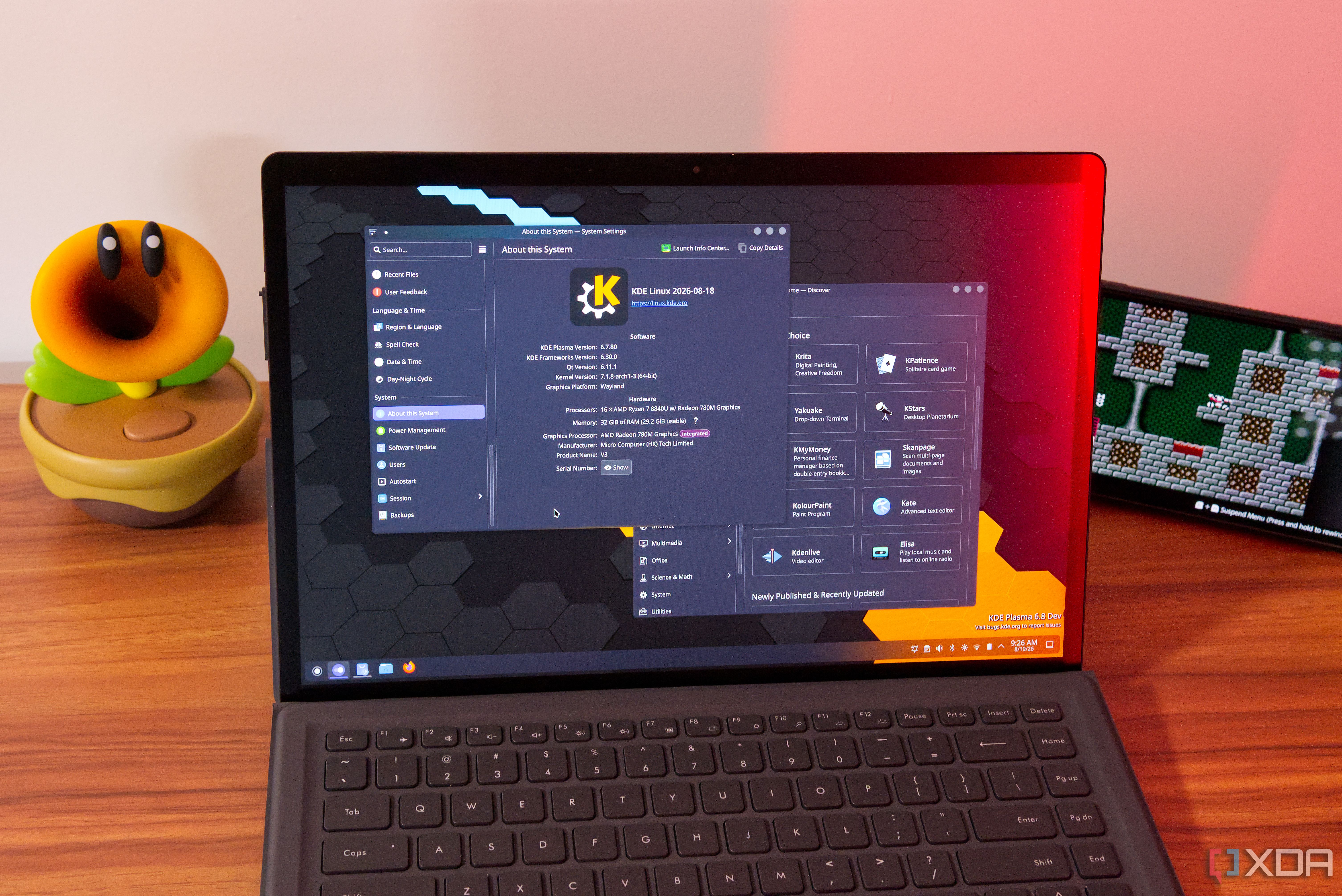 A laptop showing system information and the Discover app store on KDE Linux