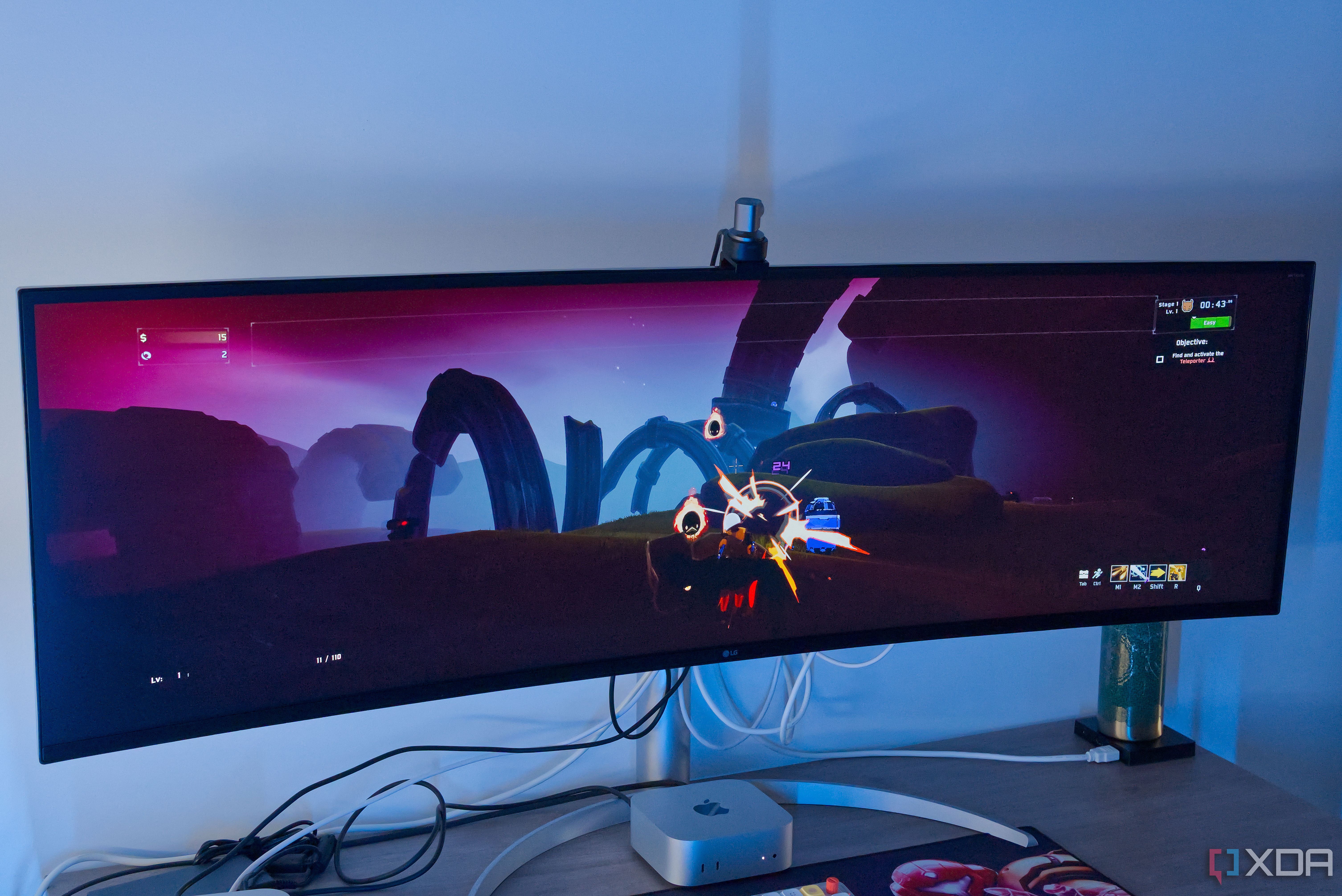 A Mac Mini in front of a monitor showing Risk of Rain 2