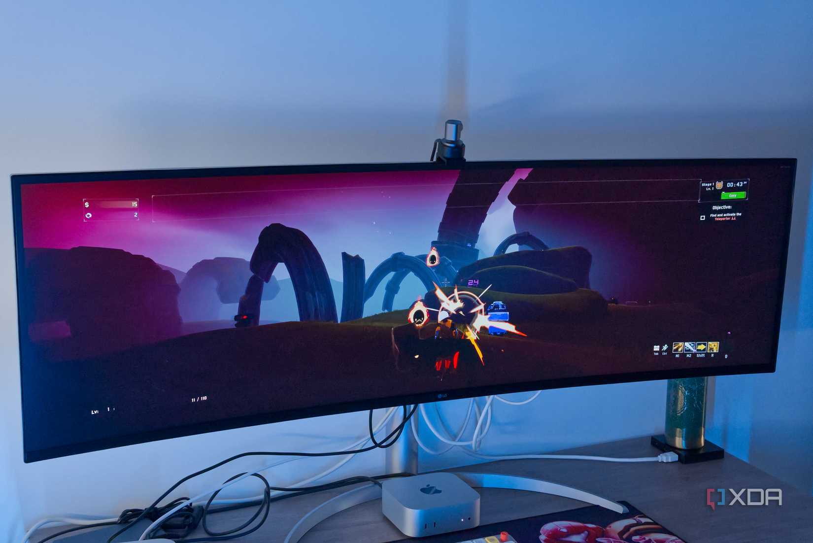 A Mac Mini in front of a monitor showing Risk of Rain 2