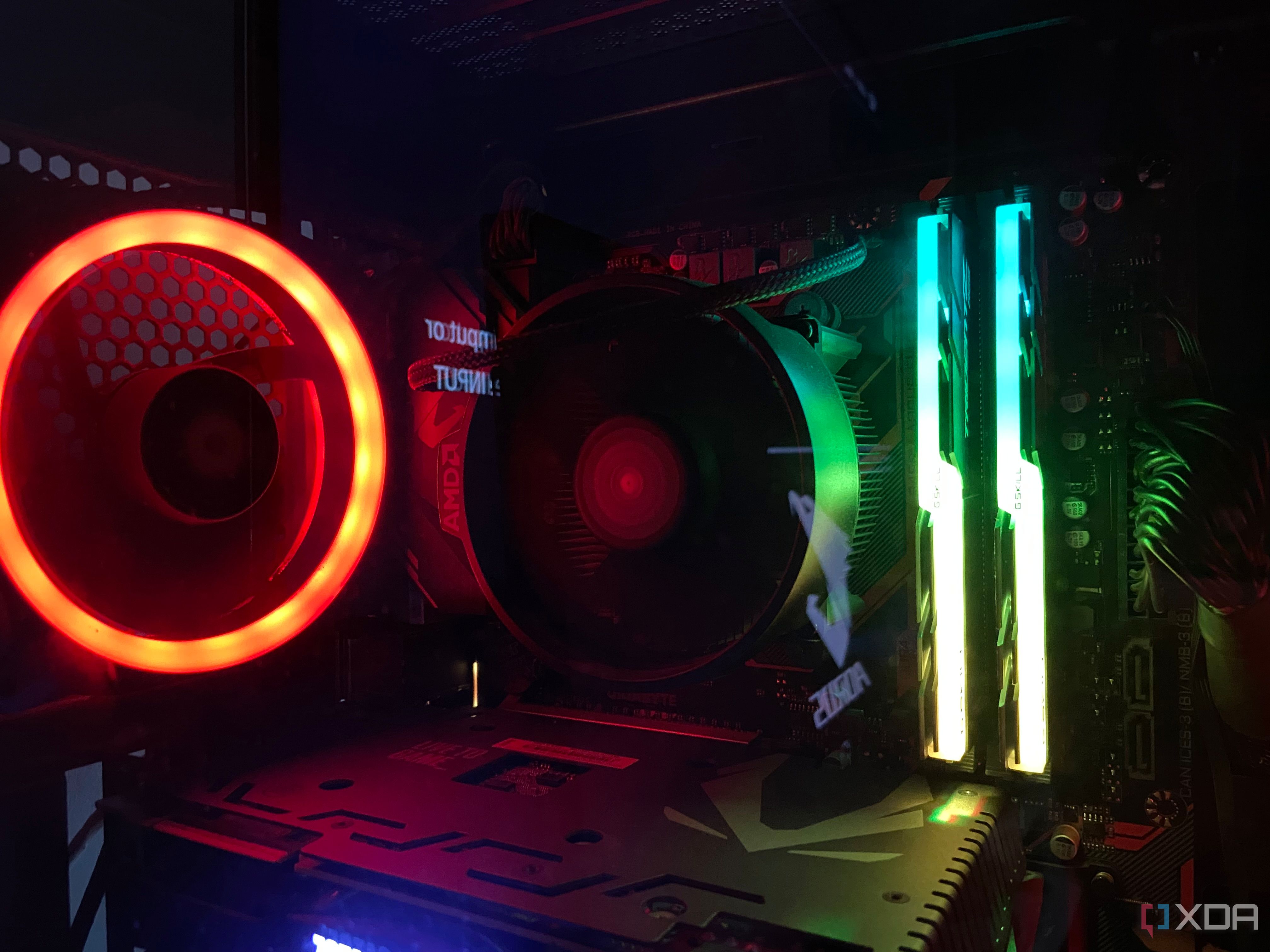 An image of a PC motherboard with DIMM slots populated and fans running. 