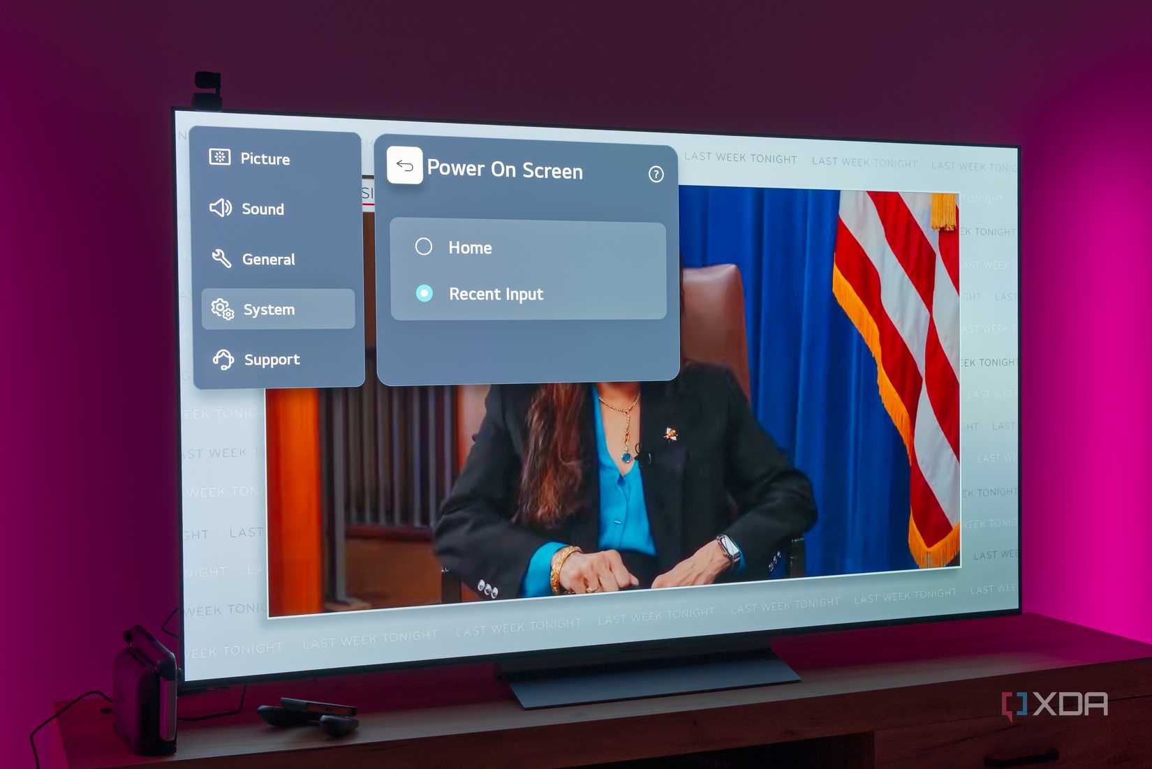 An LG TV displaying an option to choose the power-on screen, with the background showing a person sitting on a chair