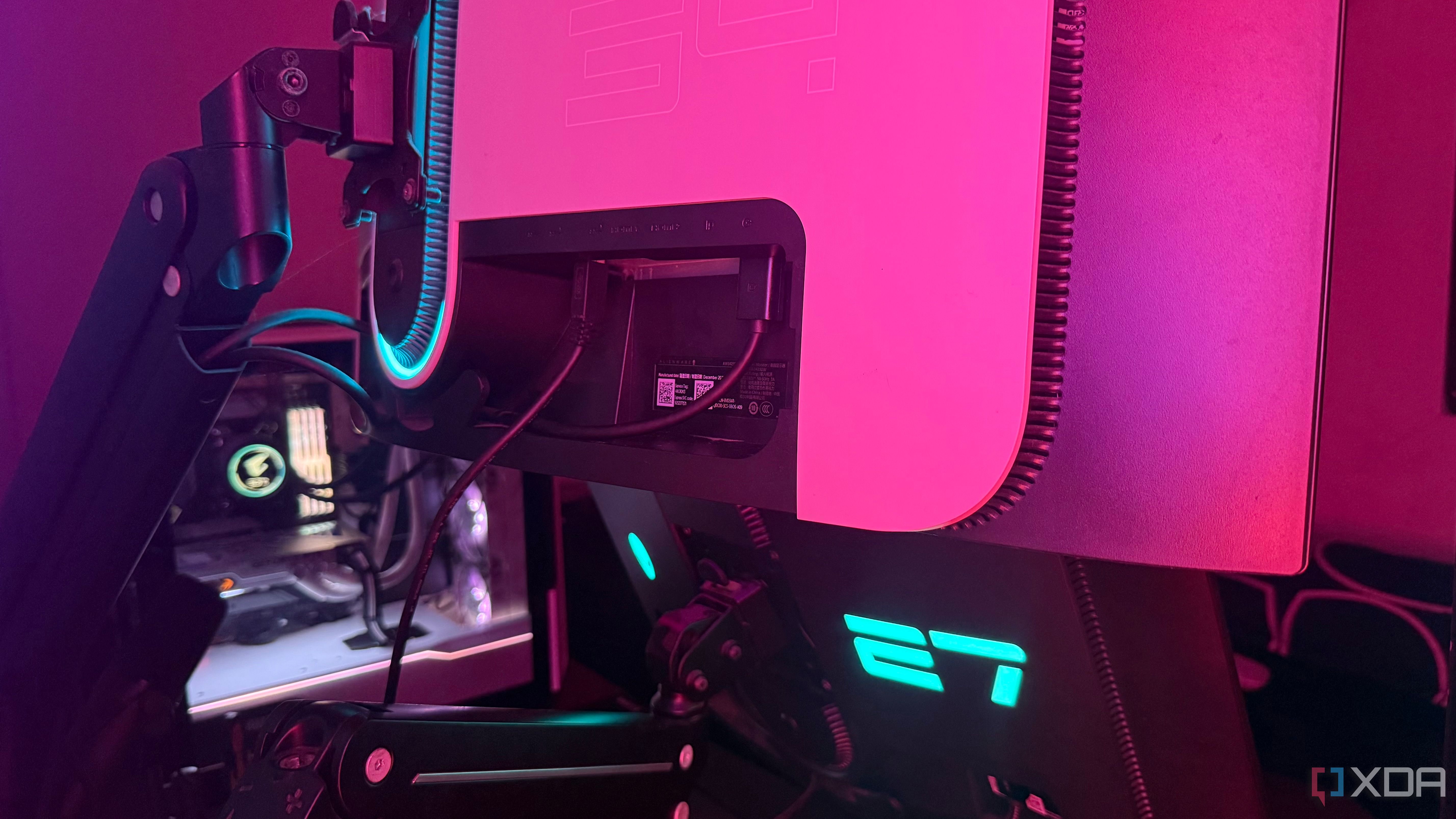 Two monitors mounted on a desk showing back ports