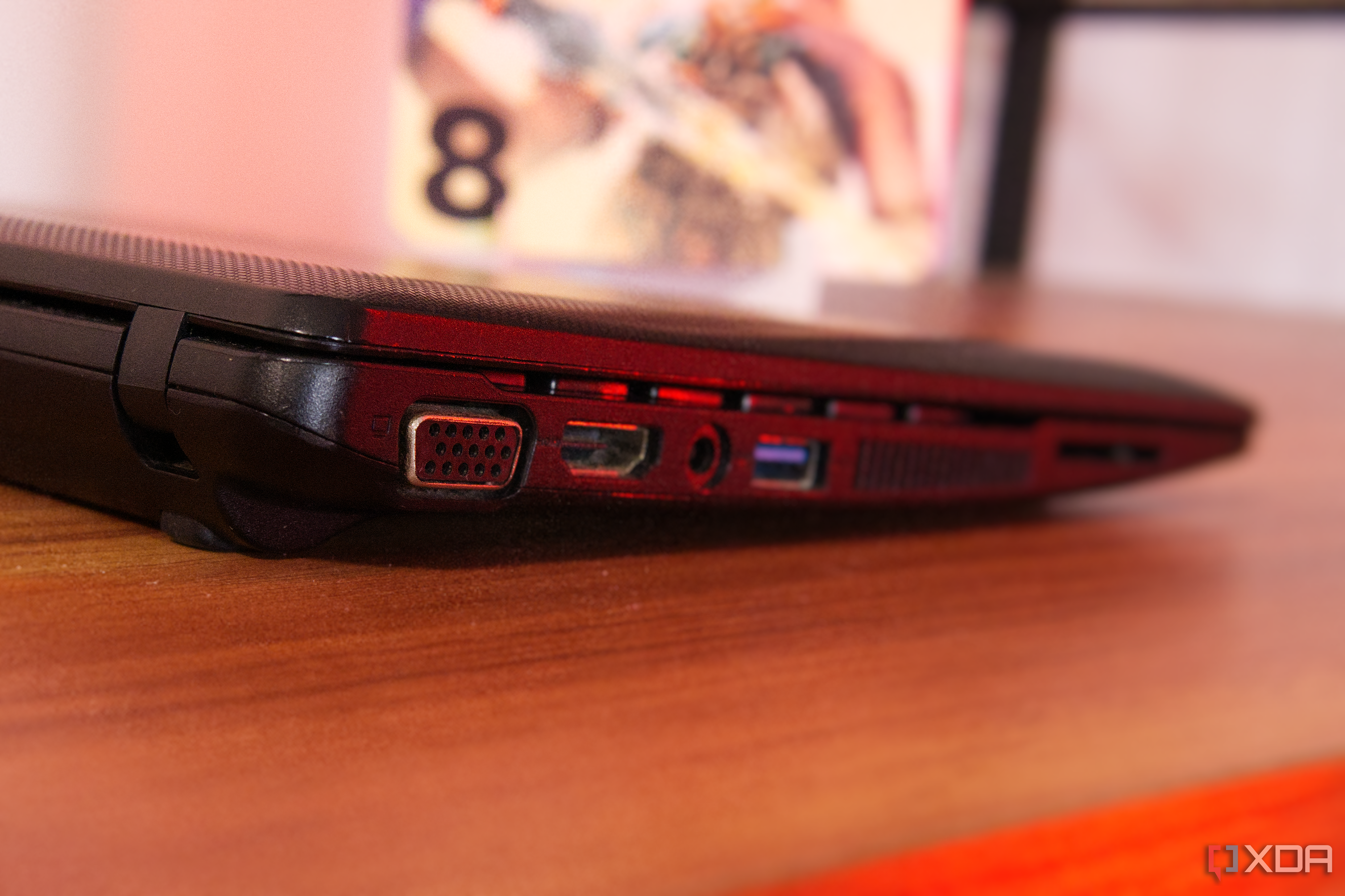 Close-up of a VGA port on a black laptop on a brown surface