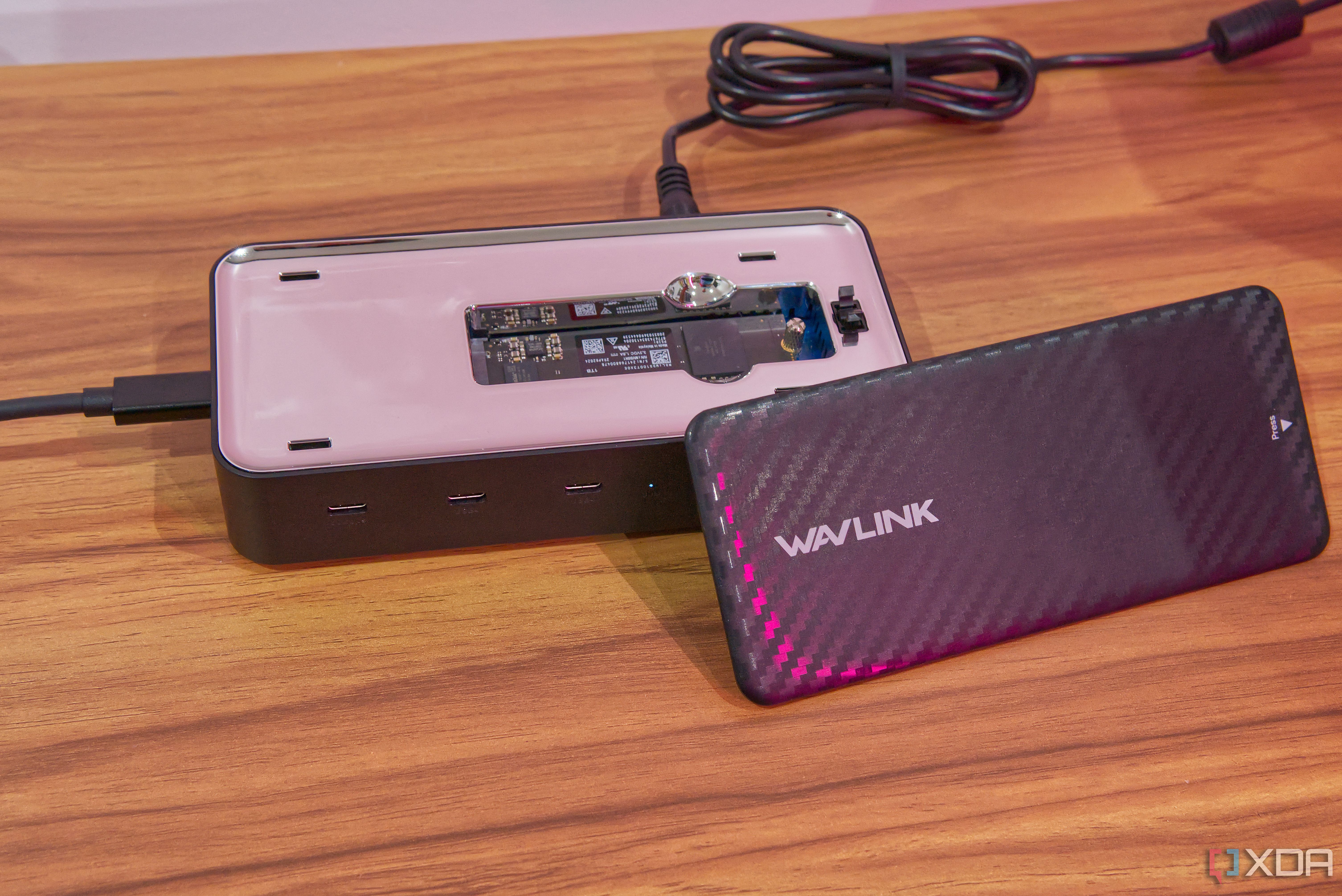 A Wavlink 6-in-1 USB4 dock with the top removedand propped up against the dock itself. An SSD can be seen in the SSD slot