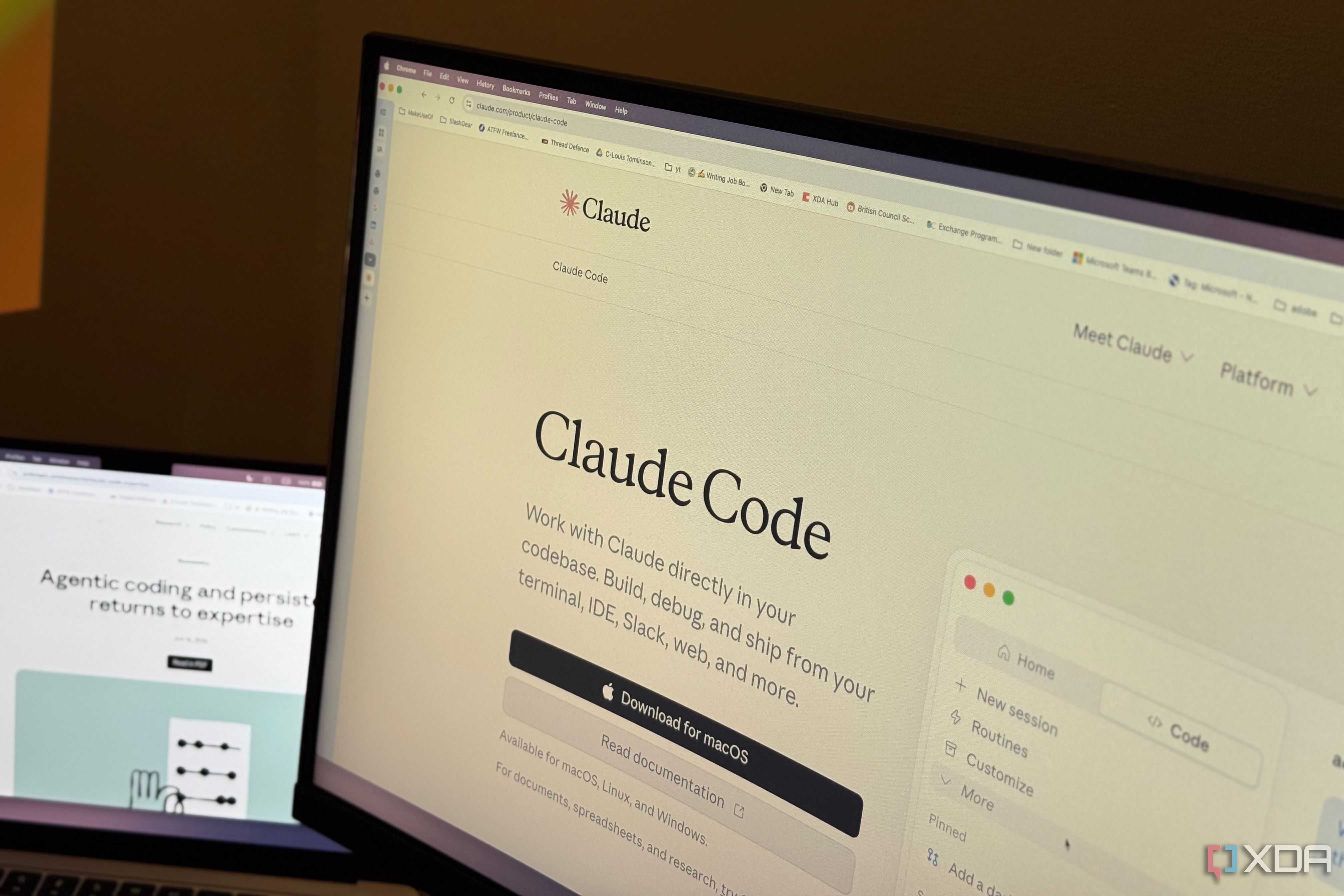 Claude Code product page open in Chrome on a monitor, laptop beside it